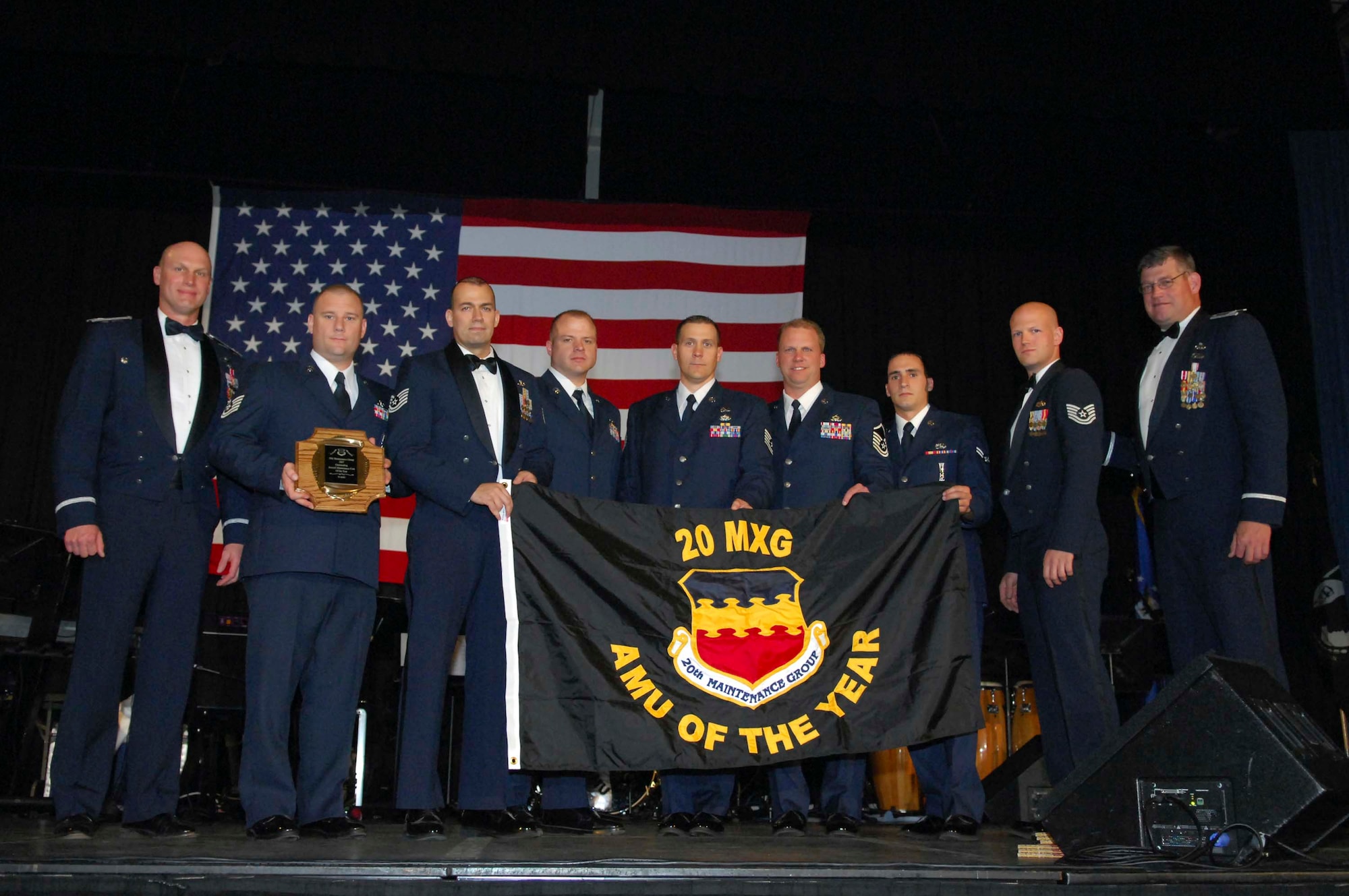 SHAW AIR FORCE BASE, S.C.-- Col. James Post, 20th Fighter Wing commander (left), and Col. Robert Hopkins, 20th Maintenance Group commander (right), award members of the 79th Aircraft Maintenance Unit the Maintenance Unit of the Year award during the 2007 Shaw Air Force Base 20th Maintenance Group Professional of the Year Awards Banquet, held at the Exhibition Center March 7. (U.S. Air Force photo/Senior Airman Kathrine McDowell)