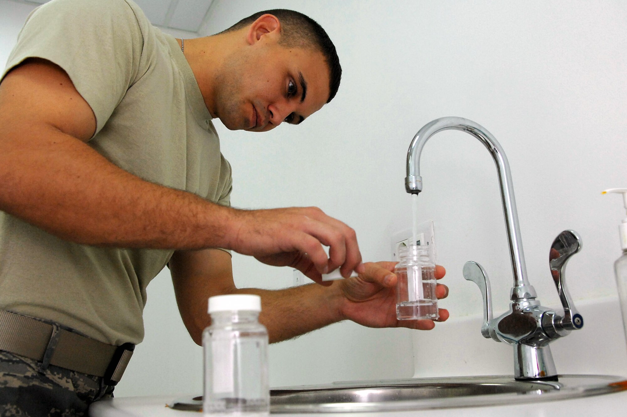 Staff Sgt. Gary Messer takes a sample of tap water for testing from the Air Force Theater Hospital March 13 at Balad Air Base, Iraq. The bioenvironmental personnel take random samples of water from many sources all over base daily to ensure its quality and safeness. Sergeant Messer, a 332nd Expeditionary Aerospace Medical Squadron bioenvironmental engineer, is deployed from Lackland Air Force Base, Texas. (U.S. Air Force photo/Senior Airman Julianne Showalter)
