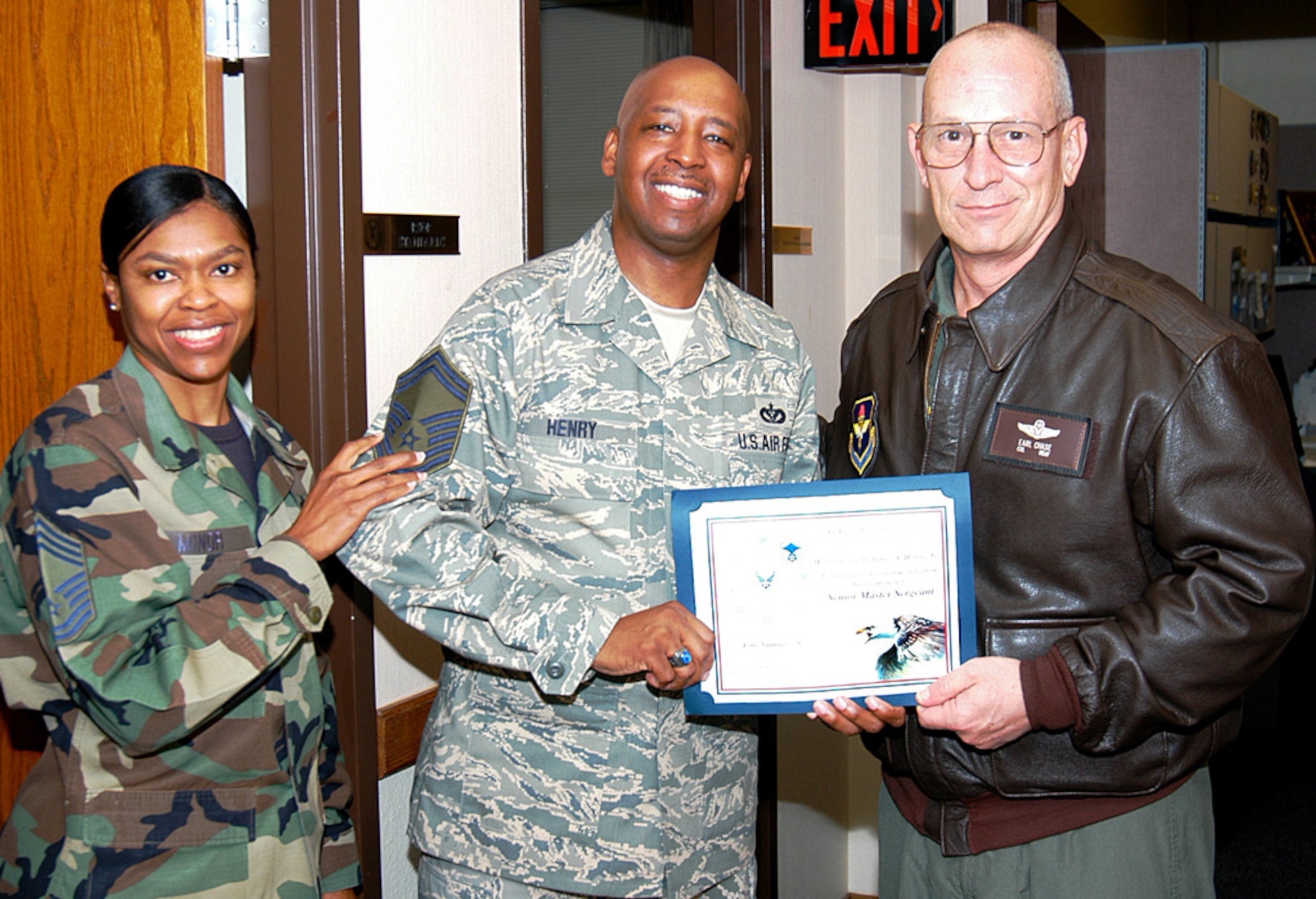 Senior Master Sgt. select James A. Henry, Headquarters Air Force Recruiting Service, gets graced with his new set of E-8 stripes on Wednesday by Chief Master Sgt. Karen Minor, left, AFRS Information Systems Division superintendent, and Col. Stan Chase, AFRS vice commander. Sergeant Henry was one of 26 AFRS master sergeants selected for promotion. (Air Force photo/Chet DelSignore) 
