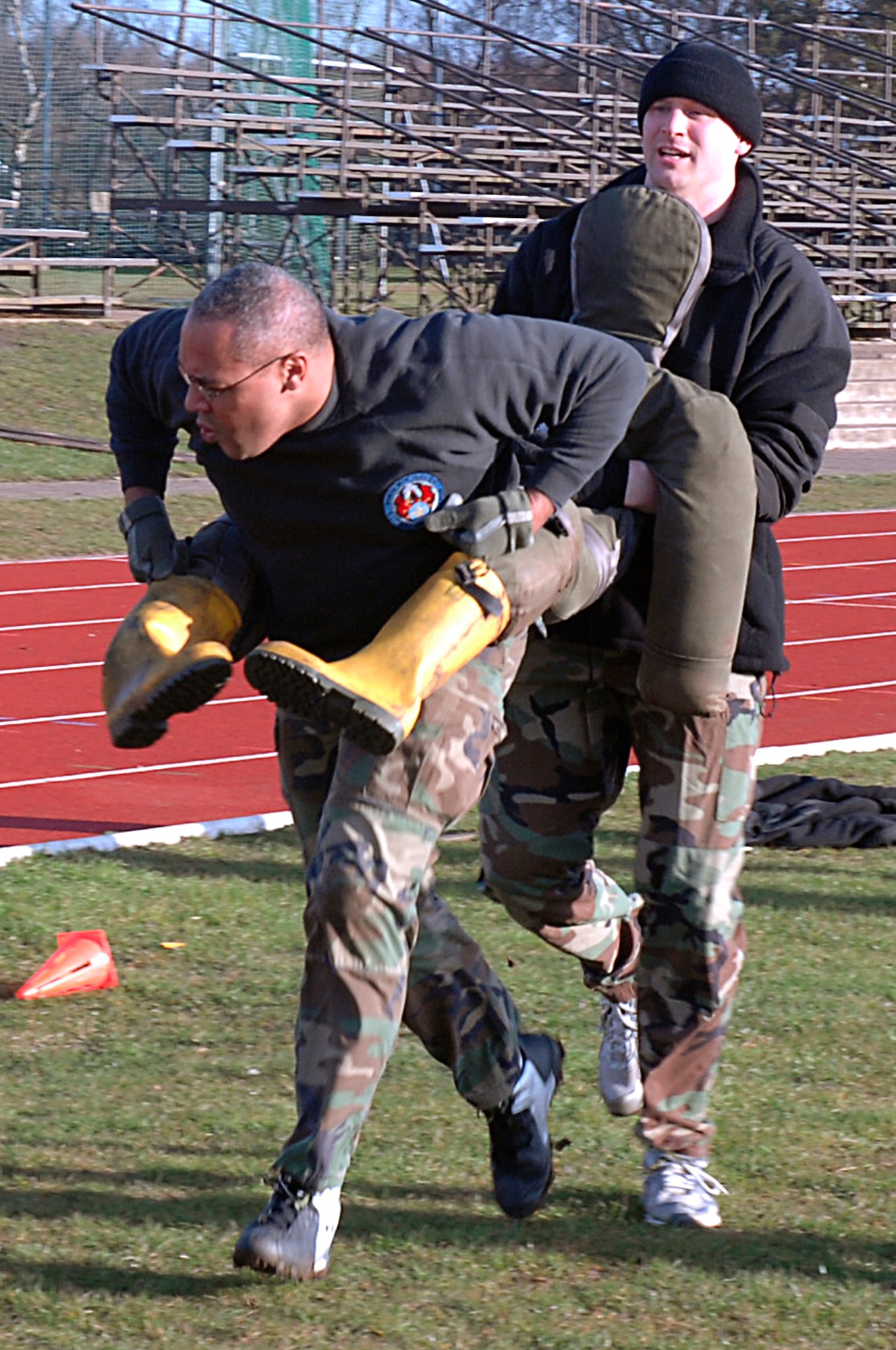 Master Sgt. Jackie Cruse and Staff Sgt. Peter Stein carry a 175 pound life-size mannequin during the 48th Security Forces Squadron Combat Olympics March 11 at RAF Lakenheath, England. These Airmen carried the dummy for 40 yards and handed it off to their team members.  This event gave Airmen a real-life experience of how difficult it would be to carry an injured person off the battle field. (U.S. Air Force photo by Senior Airman Brian J. Ellis)