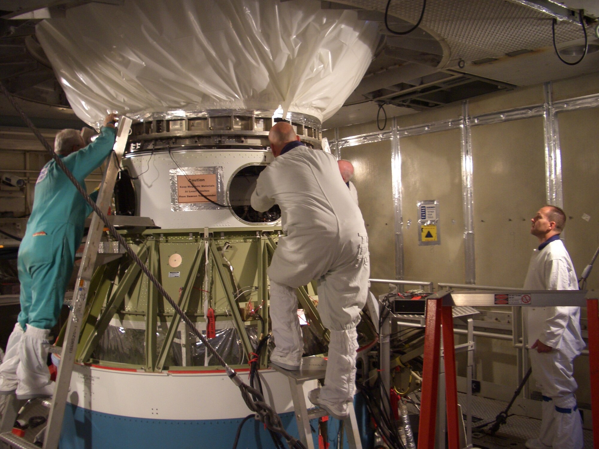 Tech. Sgt. Randall Thomas (far right), 1st Space Launch Squadron, observes mating of the GPS IIR-19 satellite to the Delta II booster scheduled for launch March 15 from Complex 17A at Cape Canaveral. (U.S. Air Force photo courtesy of 1st Space Launch Squadron)