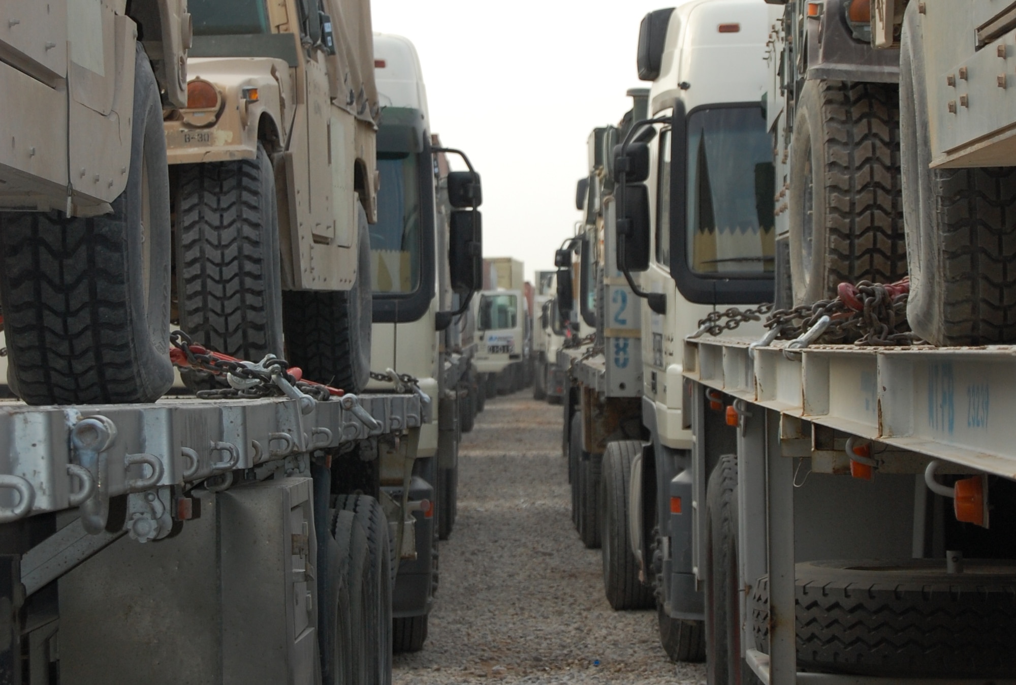 SOUTHWEST ASIA -- Endless lines of trucks assigned to the 586th Expeditionary Logistics Readiness Squadron's 70th and 424th Medium Truck Detachments sit ready and loaded for a line hual mission out of an Army camp in the Persian Gulf Region. Air Force vehicle operators and vehicle mechanics have performed in-lieu-of taskings for their Army brethren since 2004 providing gun truck security duties to the line haul missions in and around Iraq today. More than 600 of these logistics readiness warriors deploy annually to this dangerous and deadly combat mission in which countless Airmen have been killed and wounded in action by small arms fire, improvised explosive device attacks, and more. (Air Force courtesy photo)