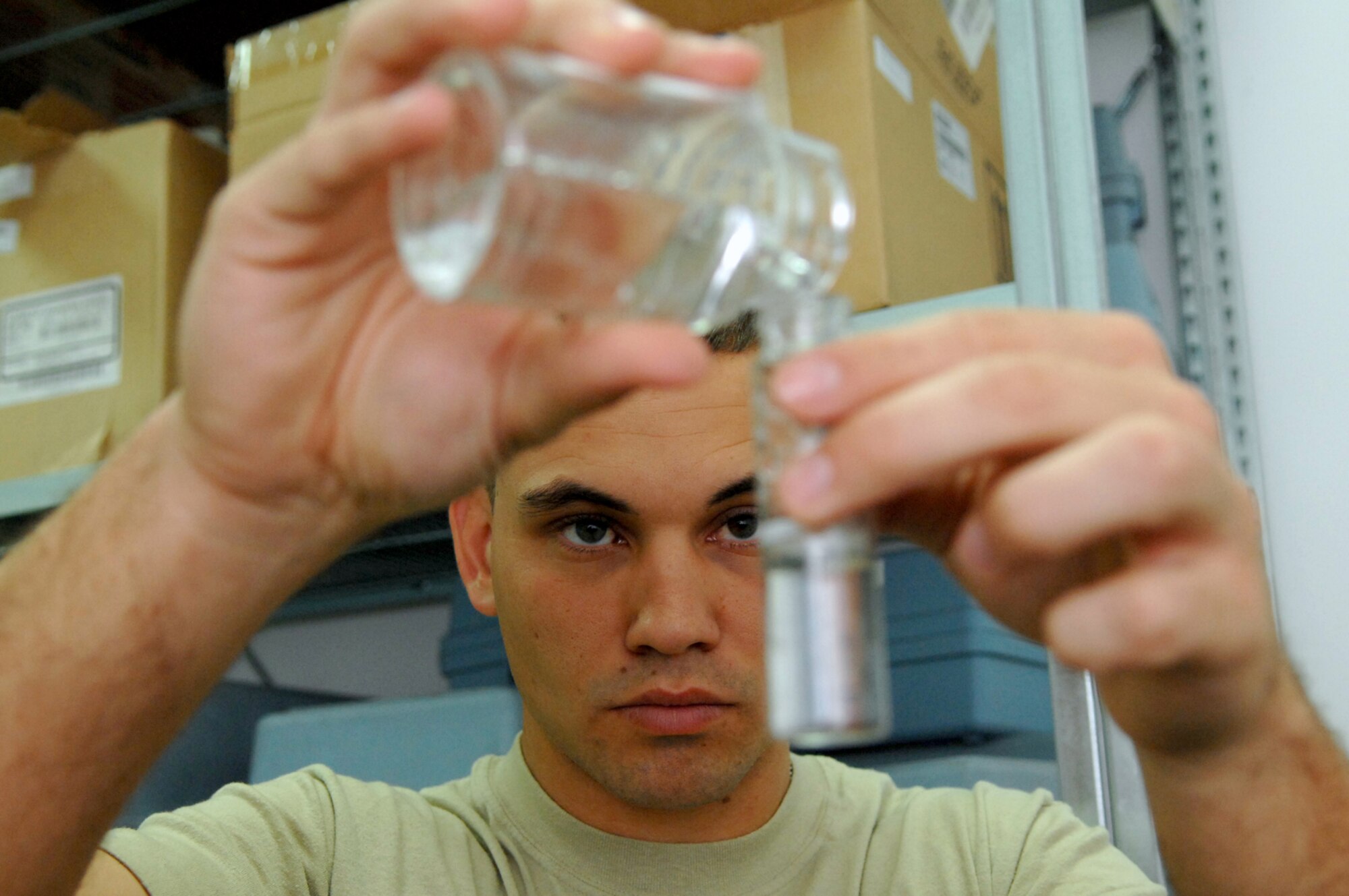 BALAD AIR BASE, Iraq -- -- Staff Sgt. Gary Messer, 332nd Expeditionary Aerospace Medical Squadron bioenvironmental engineer, transfers a sample of tap water to a tube before performing tests to confirm that the water is free from bacteria here, March 13. Sergeant Messer is deployed from Lackland Air Force Base, Texas. (U.S. Air Force photo/ Senior Airman Julianne Showalter)