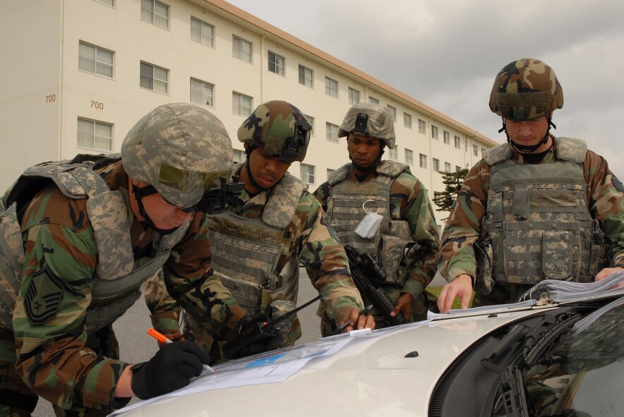 Master Sgt. Scott Elmblad and fellow Airmen of 18th Security Forces Squadron mark the locations of their cordon on a map and check the UXO checklists in a conventional UXO attack scenario near Bldg. 705, during the 2008 Pacific Air Forces Operational Readiness Inspection at Kadena Air Base, Japan, March 13, 2008. PACAF is conducting the inspection from March 9 to 15 to validate the mission readiness of the 18th Wing. (U.S. Air Force photo/Staff Sgt. Chrissy FitzGerald) 