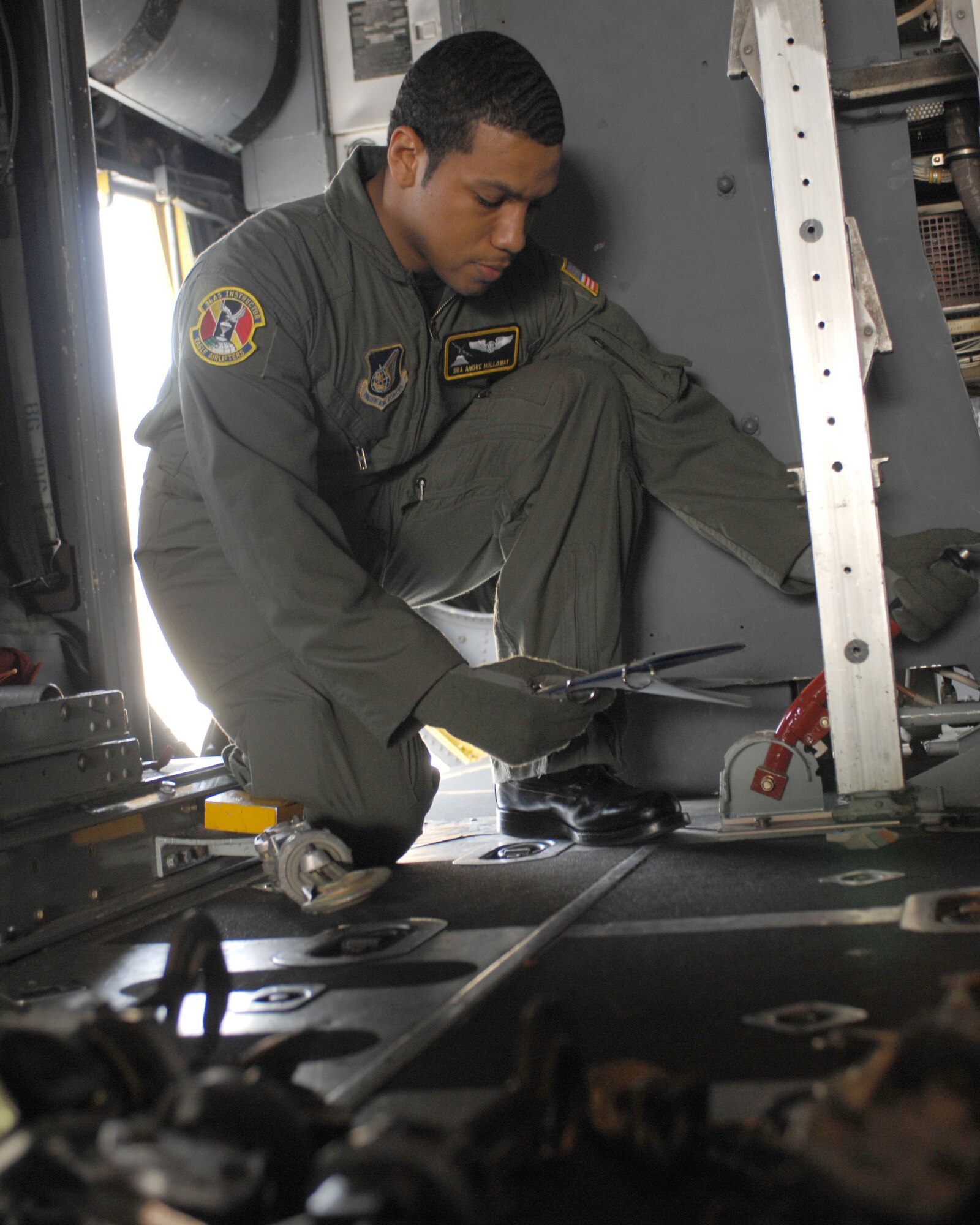 YOKOTA AIR BASE, Japan -- Senior Airman Andre Holloway, 36th Airlift Squadron, retracts the locks of a C-130 Hercules in preparation for cargo to be loaded during a training exercise here March 12. (U.S. Air Force photo/Senior Airman Laszlo Babocsi)