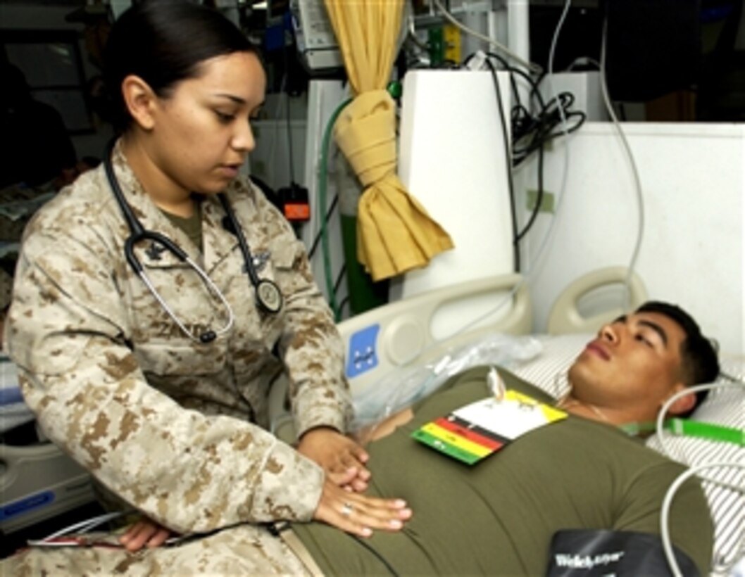 U.S. Navy Petty Officer 2nd Class Marlene Zamudio provides simulated treatment to Cpl. Jesse Koontz in the intensive care unit aboard the amphibious assault ship USS Peleliu during a mass casualty exercise at sea in the Pacific Ocean, March 13, 2008.
