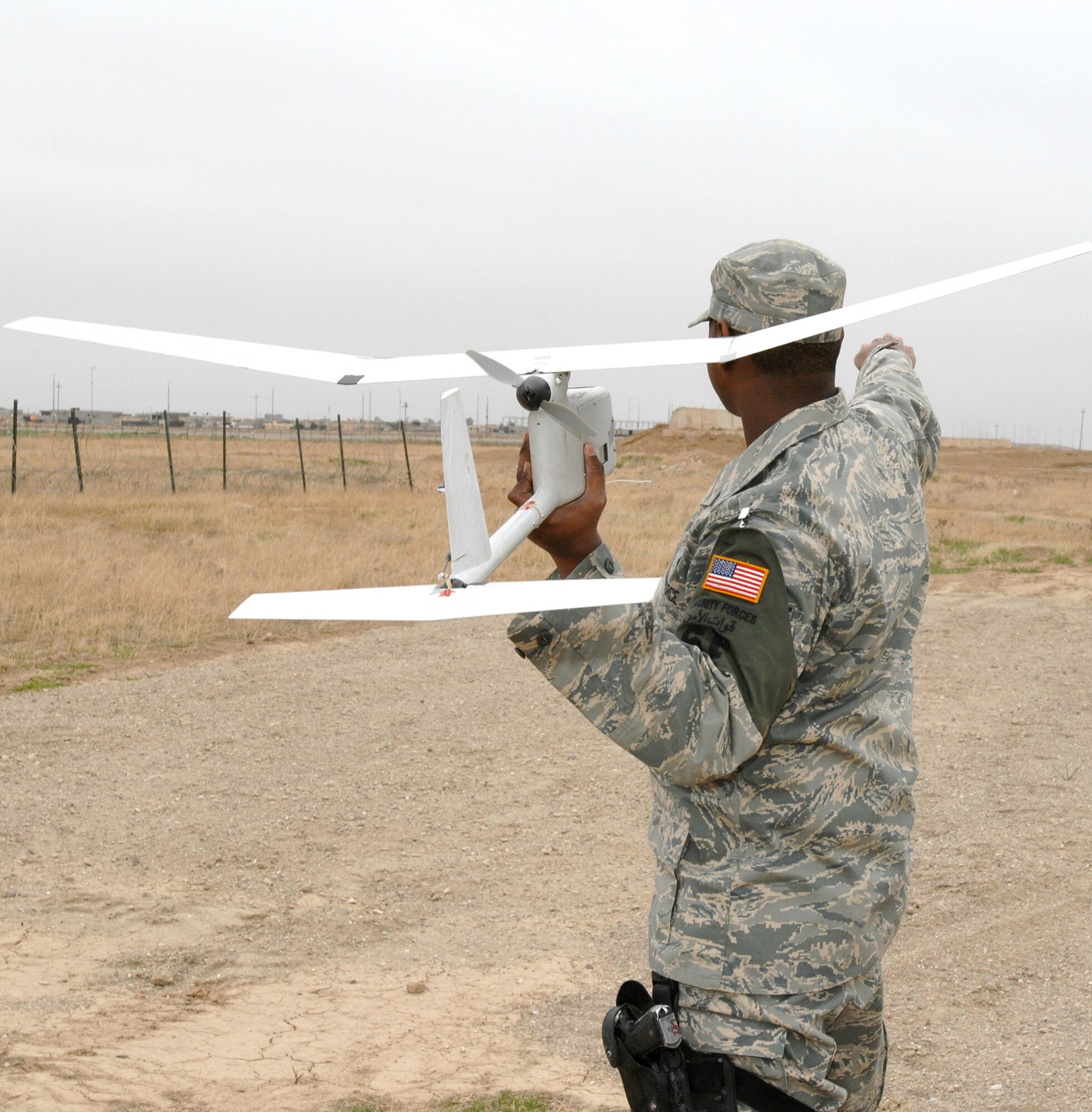Senior Airman Glenn Gerald, 506th Expeditionary Security Forces Squadron Raven operator, prepares to put an RQ-11 Raven in flight during a recent mission here. Despite weighing in at less than 5 pounds, these unmanned aerial vehicles play a vital role in securing the base and surrounding neighborhoods. (U.S. Air Force photo by Senior Master Sgt. Don Senger)