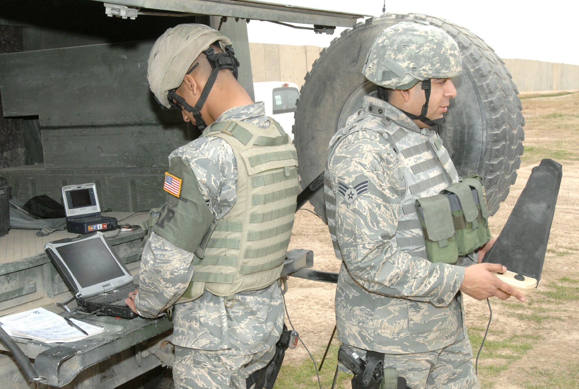 Airman 1st Class Melvin Silva (right) and Senior Airman Jacob Galindo, 506th Expeditionary Security Forces Squadron Raven operators, work together to view images transmitted from an RQ-11 Raven during a recent mission here. Despite weighing in at less than five pounds, this unmanned aerial vehicle plays a vital role in securing the base and surrounding neighborhoods. (U.S. Air Force photo by Senior Master Sgt. Don Senger)