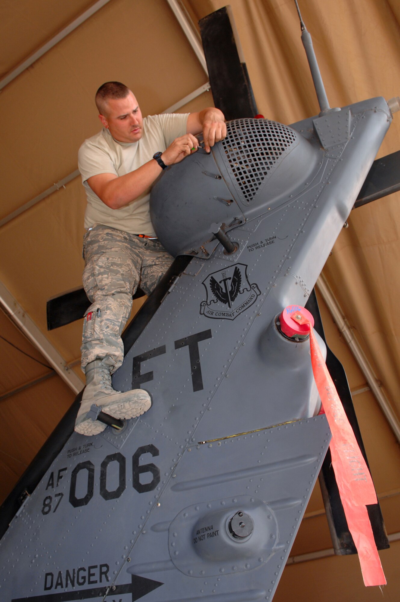 BALAD AIR BASE, Iraq -- Staff Sgt. Tait Delzer, 64th Expeditionary Helicopter Maintenance Unit crew chief, re-installs a tail rotor cover on an HH-60G Pave Hawk helicopter here, March 12. Balad crew chiefs performed an inspection on the aircraft after it had been flown 300 hours. During such inspections, all aircraft panels and covers are removed for preventative maintenance on aircraft systems and equipment. Sergeant Delzer is deployed from Moody Air Force Base, Ga. (U.S. Air Force photo/ Senior Airman Julianne Showalter)