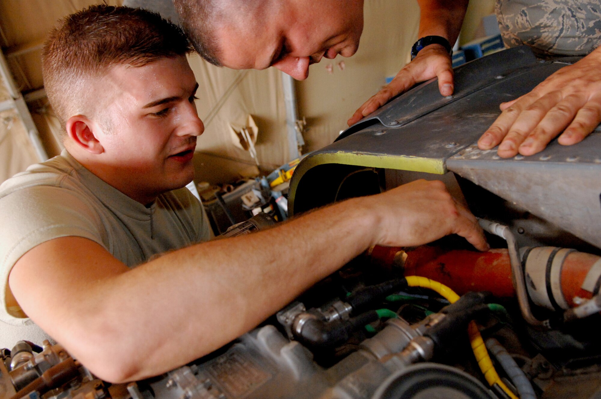 BALAD AIR BASE, Iraq -- Airman 1st Class Donald Baker and Staff Sgt. Tait Delzer, 64th Expeditionary Helicopter Maintenance Unit crew chiefs, install the left engine air intake on an HH-60G Pave Hawk helicopter here, March 12. The crew chiefs performed an inspection after the helicopter had been flown 300 hours of all major components to ensure they were still in working order. Both Airman Baker and Sergeatn Delzer are deployed from Moody Air Force Base, Ga. (U.S. Air Force photo/ Senior Airman Julianne Showalter)