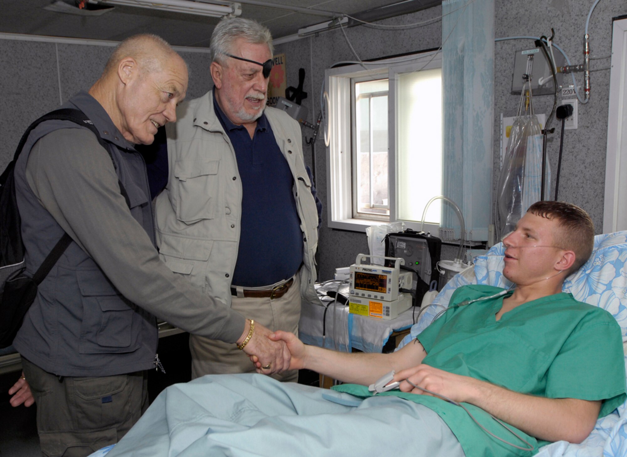 Medal of Honor Recipients, Colonel Robert L. Howard, United States Army (Retired) and Captain John J. McGinty, III, United States Marine Corps (Retired) visit Private Andrew Knar, an Army solider currently being hospitalized at Manas AB, Kyrgyz Republic on March 15, 2008.  Both recipients  received their medals from actions taken during the Vietnam War which serves as motivation to the men and women all over the Area of Responsibility. (U.S. Air Force/Senior Airman Tabitha Kuykendall)