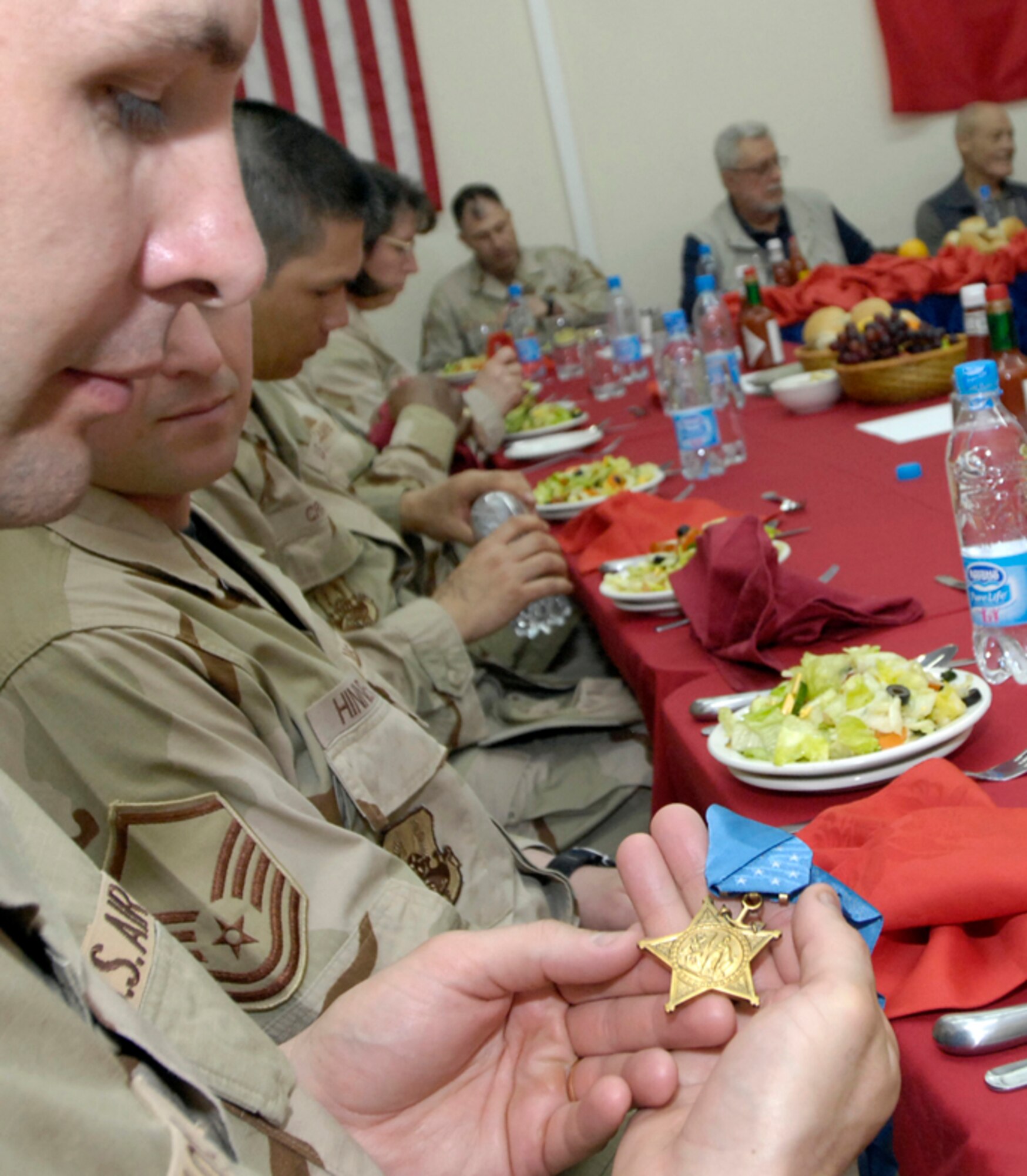Master Sergeant Kent Klotz, 376th Expeditionary Logistics Squadron, admires the Medal of Honor as the Recipients, Colonel Robert L. Howard, United States Army (Retired) and Captain John J. McGinty, III, United States Marine Corps (Retired) share their experiences with the Top 3 Council, Manas AB, Kyrgyz Republic on March 15, 2008. Both recipients received their medals from actions taken during the Vietnam War which serves as motivation to the men and women all over the Area of Responsibility. (U.S. Air Force/Senior Airman Tabitha Kuykendall)