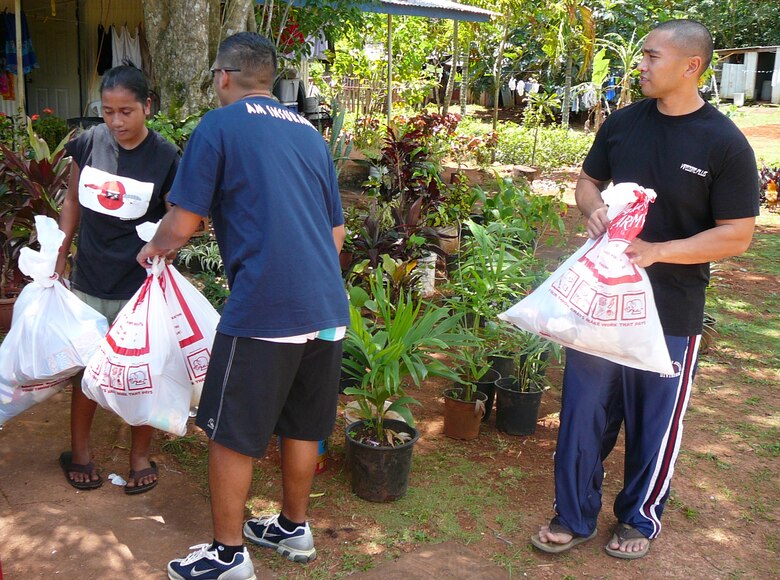 Senior Airmen Jacob Barnes, Guam Air National Guard, and Acquarius Omambac, 36th Munitions Squadron, present bags of food and clothing to a member of the local Guam community.  Twenty students from Andersen’s Airman Leadership School Class 08-C volunteered four hours working with The Salvation Army March 15, 2008.  More than 100 bags of clothes and food donated by the Andersen community were bagged and personally delivered to 25 homes consisting of 99 adults and 87 children in Dededo, Guam.  For information on how to donate items to the Guam community through The Salvation Army, call 647-1569.   