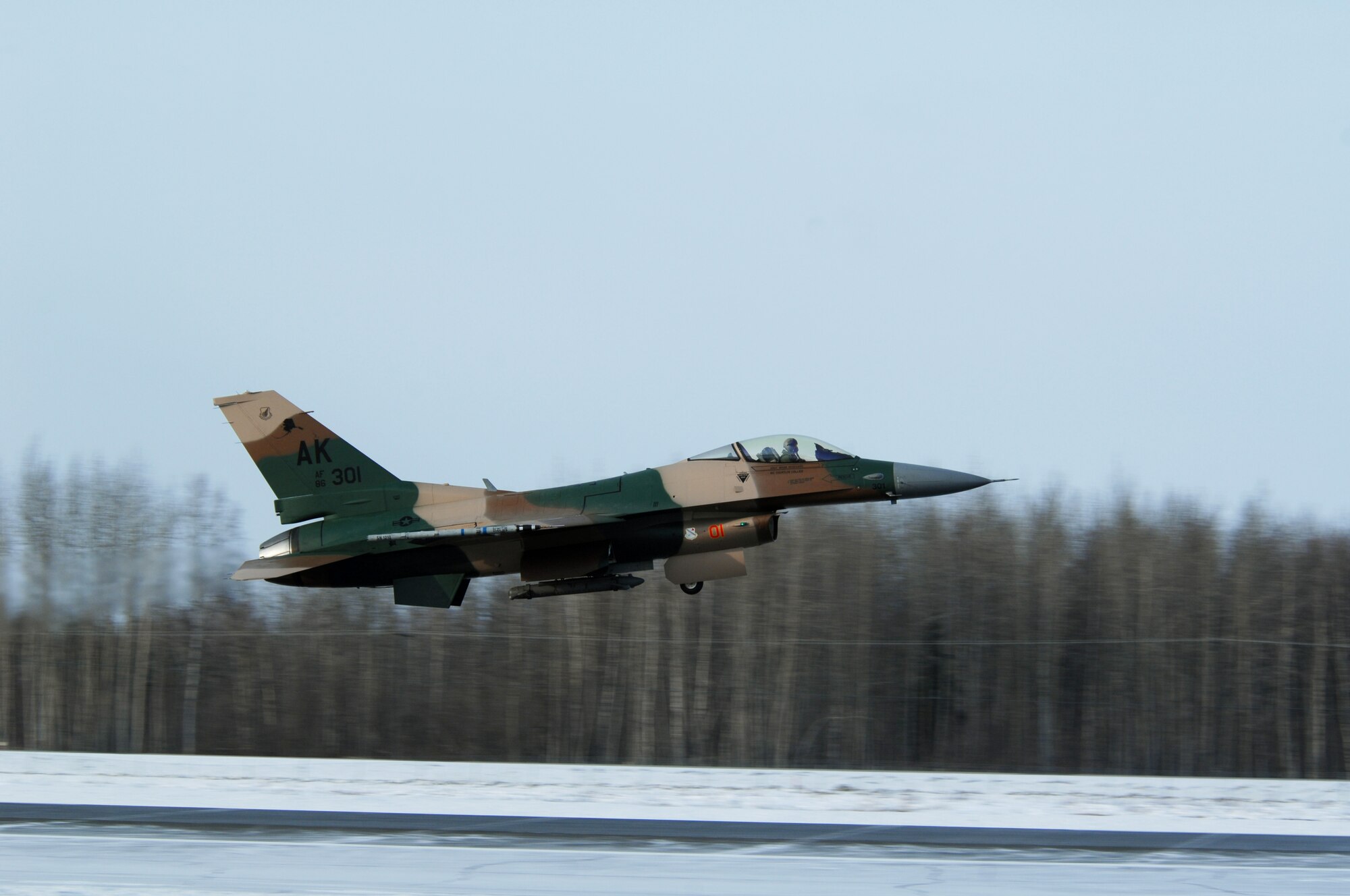 An F-16 Fighting Falcon 'Aggressor' with lizard flanker color scheme takes off at Eielson Air Force Base, Alaska for a training mission over the Pacific Alaska Range Complex March 17. The 18th Aggressor Squadron's F-16 fly as the opposing force during Red Flag-Alaska exercises using enemy tactics, techniques and procedures to give a realistic simulation of aerial combat. (U.S. Air Force photo by Airman 1st Class Christopher Griffin) 
