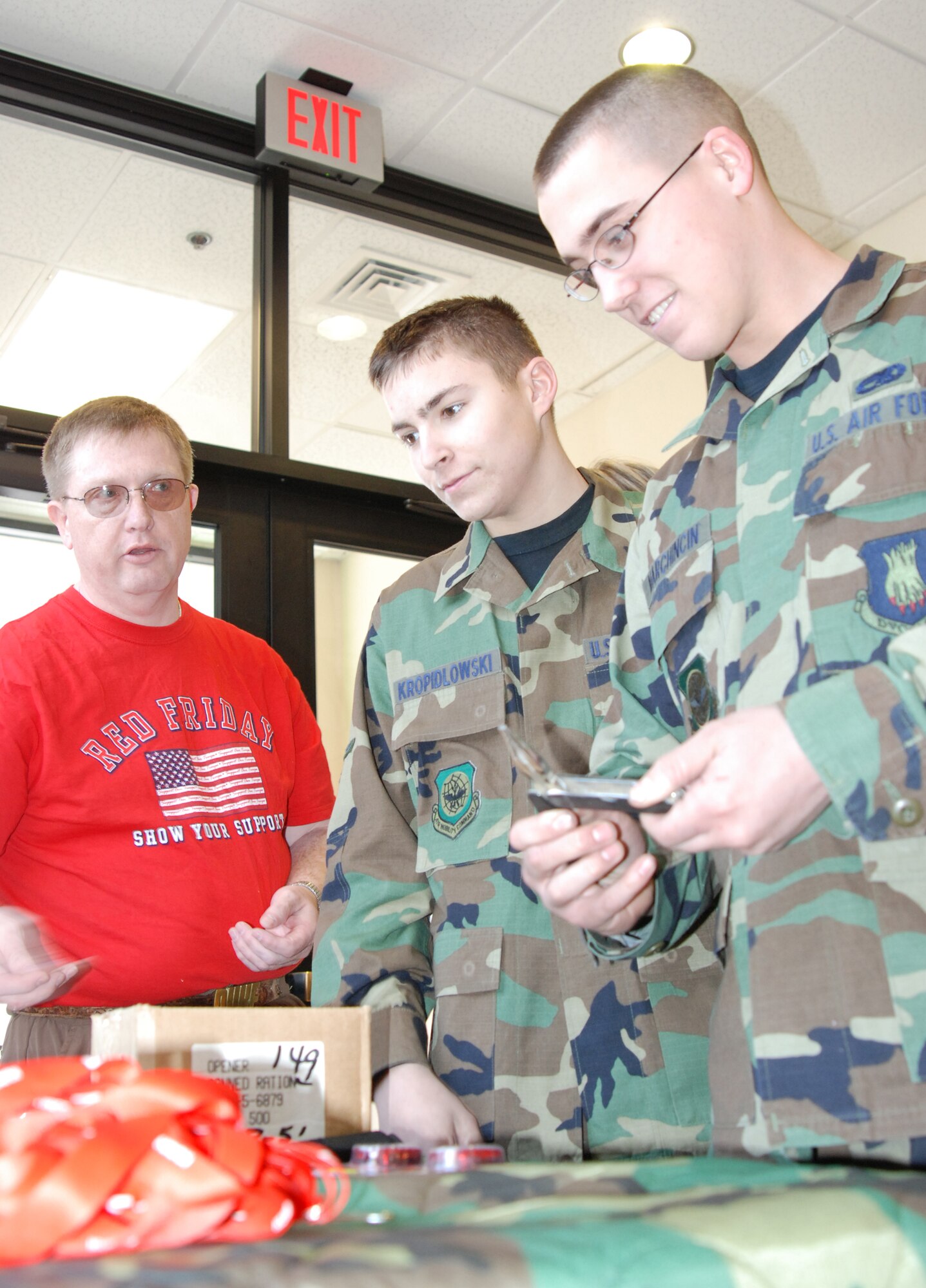 McConnell Air Force Base, Kan. --Bruce Jolly, former Navy Seaman offers free small gifts of outdoor recreation gear to Airmen Dale Kropidlowski and Adam Marchincin, 22nd Maintenance Squadron, March 14, at the Chisholm Trail Dining Facility. (photo by Airman 1st Class Jessica Lockoski)