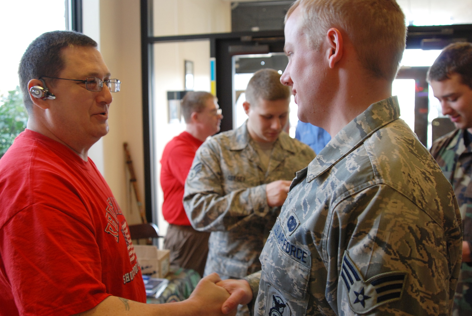 McConnell Air Force Base, Kan. --Disable military veterans, Dennis Mitchell and Bruce Jolly, talk to McConnell military members about the importance of establishing military health benefits at the Chisholm Trail Dining Facility, March 14. Their “2008 Tour of Duty” brings them to military installations around the Nation offering servicemembers free outdoor sporting equipment in appreciation of their service in the military.  (photo by Airman 1st Class Jessica Lockoski)