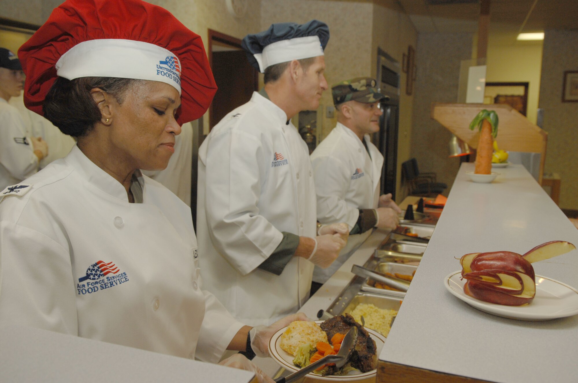 (Left to right)Colonel Renita Alexander, 28th Mission Support Group commander; Col. Peter Castor, 28th Bomb Wing vice commander; and Lt. Col. Stephen Mamakos, 28th Civil Engineer Squadron individual mobilization augmentee; serve gourmet cuisine at the Bandit Inn Dining Facility March 11. This recreated Airmen Appreciation Meal was an opportunity for base leadership to thank the Ellsworth Airmen for their service and hard work. (U.S. Air Force photo/Airman 1st Class Joshua Seybert)