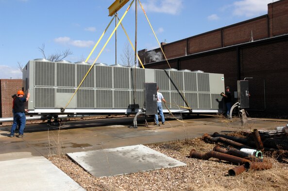 WHITEMAN AIR FORCE BASE, Mo. -Members of the 509th Civil Engineer Squadron position the 275 ton air conditioning unit for final placement Mar. 14. The 509th CES hoisted the avionic simulator cooling unit into place with a 200-foot tall crane over a nine foot brick wall without incident. (U.S. Air Force photo/Staff Sgt Charles D. Larkin Sr.)