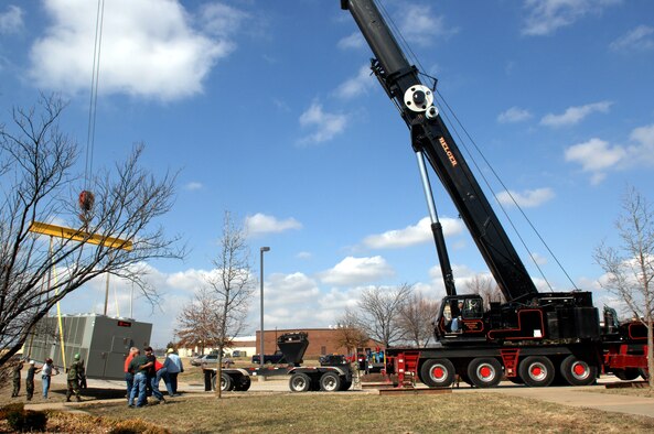 WHITEMAN AIR FORCE BASE, Mo. -Members of the 509th Civil Engineer Squadron stabilize a 275 ton air conditioning unit at middle position Mar. 14. The 509th CES hoisted the avionic simulator cooling unit into place using a 200-foot tall crane brought in specifically for this task. (U.S. Air Force photo/Staff Sgt Charles D. Larkin Sr.)  