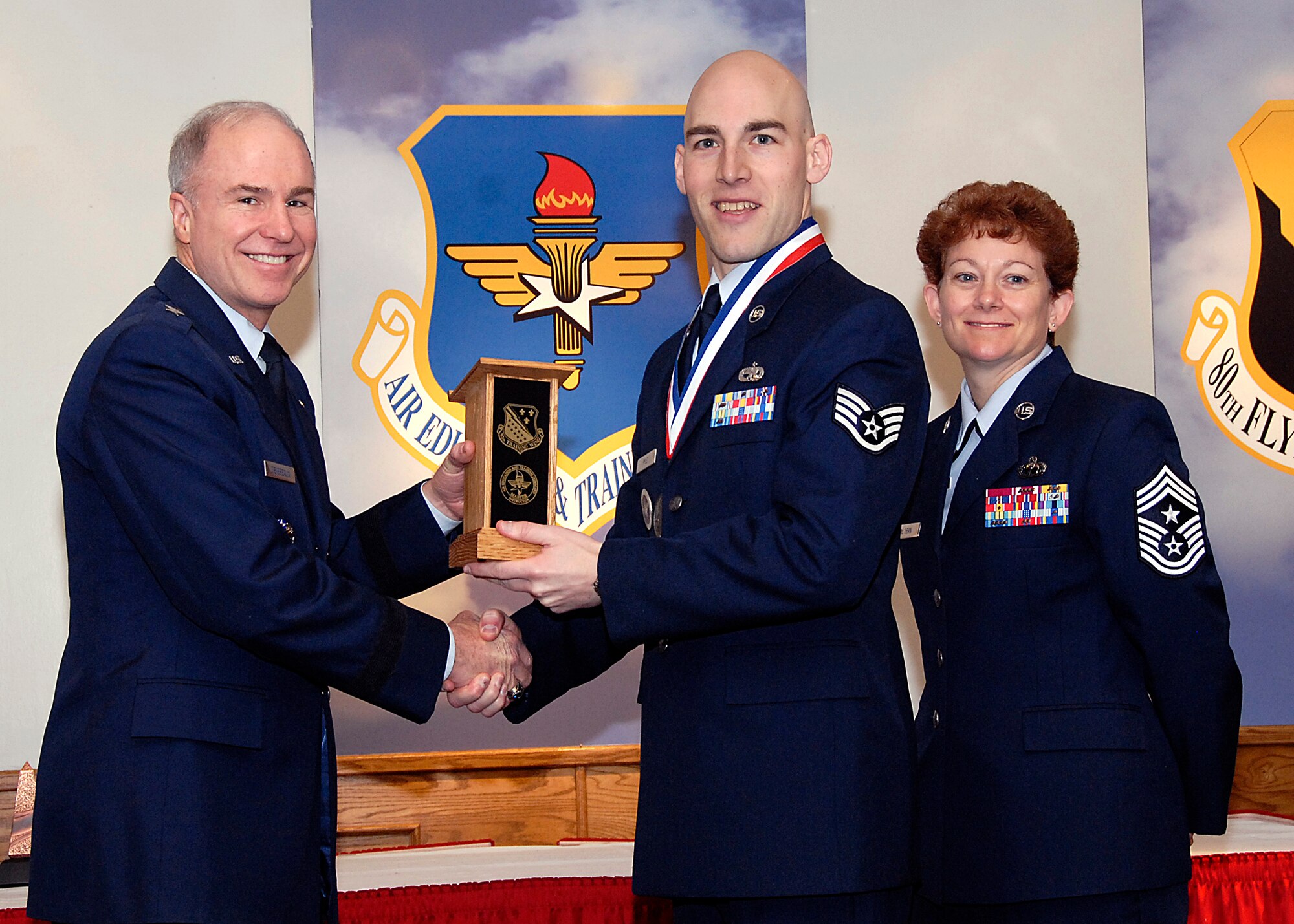 Brig. Gen. Richard Devereaux, 82nd Training Wing commander, presents Staff Sgt. Travis Pyle, 365th Training Squadron, the NCO Instructor of the Year award March 14 at the Annual Tech Training Awards. (U.S. Air Force photo/Harry Tonemah)