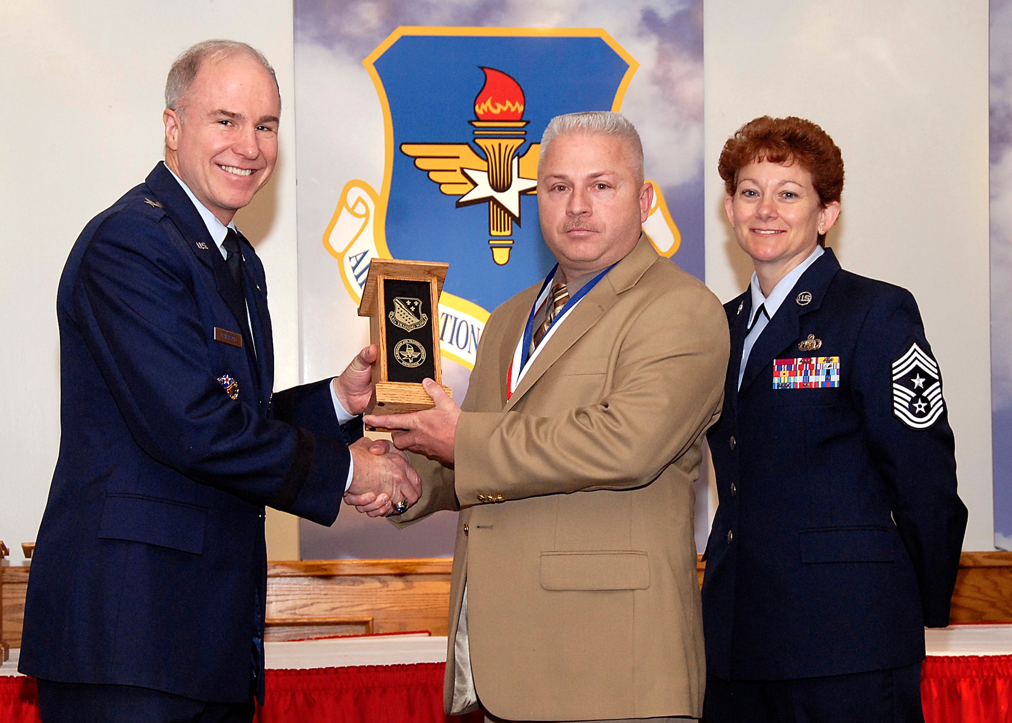Brig. Gen. Richard Devereaux, 82nd Training Wing commander, presents Michael Jackson, 82nd Training Group, the Civilian Instructor of the Year award March 14 at the Annual Tech Training Awards. (U.S. Air Force photo/Harry Tonemah)