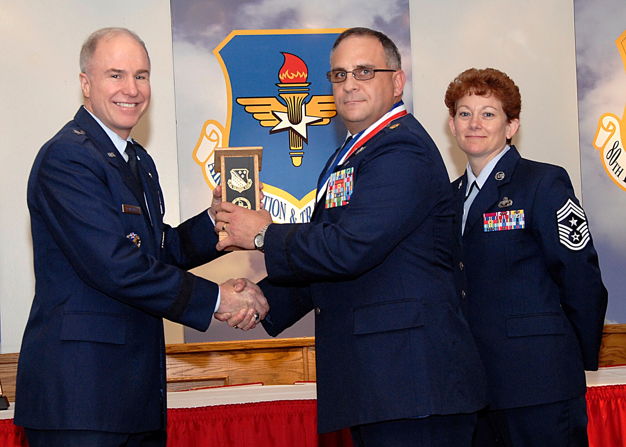 Brig. Gen. Richard Devereaux, 82nd Training Wing commander, presents Maj. Andrew Reimund, 381st Training Squadron, the Officer Instructor of the Year award March 14 at the Annual Tech Training Awards. (U.S. Air Force photo/Harry Tonemah)