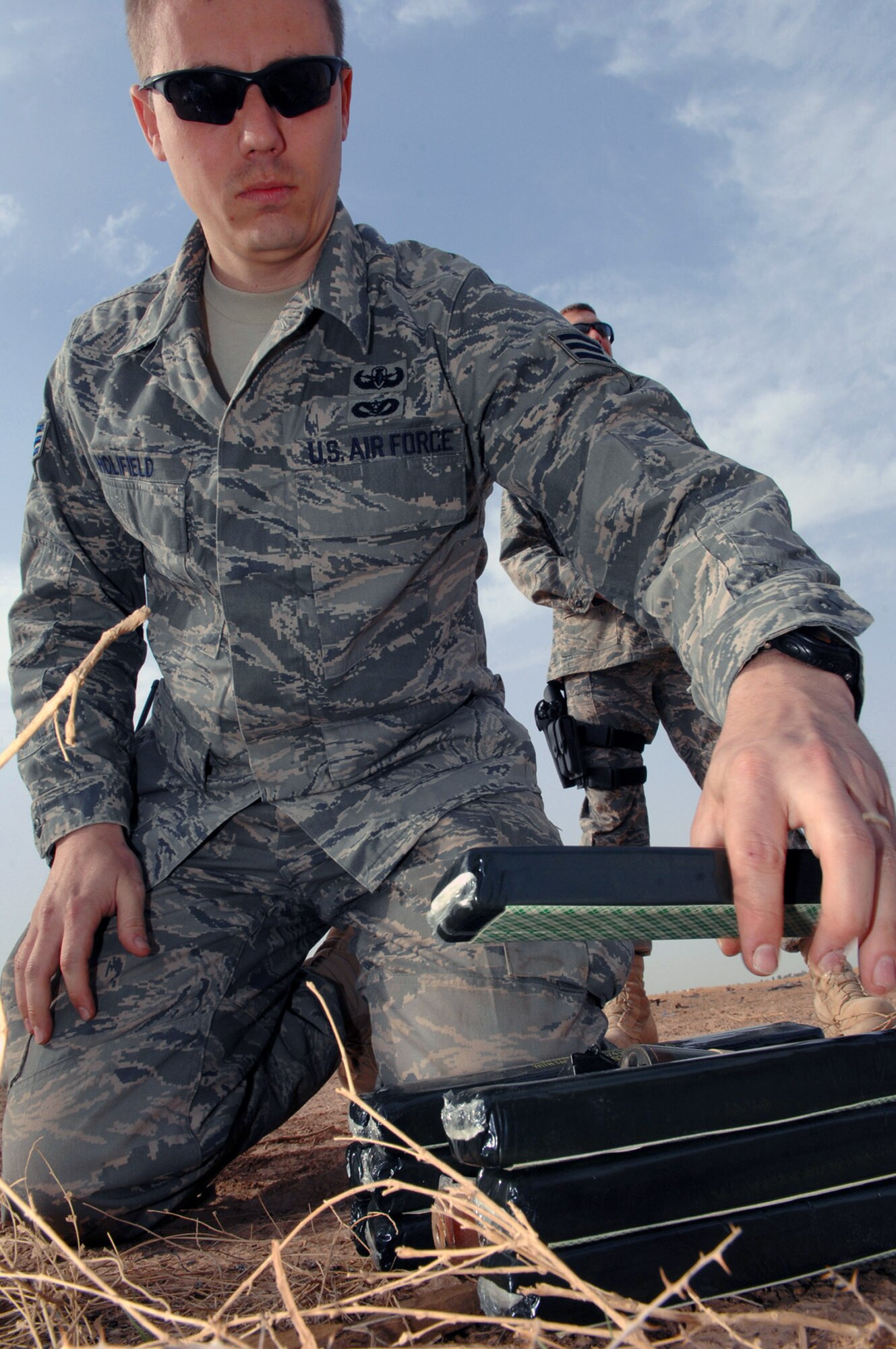 Senior Airman Stephen Holifield places C-4, an explosive substance, on top of unexploded ordnances to create a controlled detonation March 13 at Balad Air Base, Iraq. Unexploded ordnances that have been collected from indirect fire attacks must be blown up to prevent them from reentering opposing forces' hands. Airman Holifield is a 332nd Expeditionary Civil Engineer Squadron explosive ordnance disposal technician deployed from Hurlburt Field, Fla. (U.S. Air Force photo/Senior Airman Julianne Showalter) 