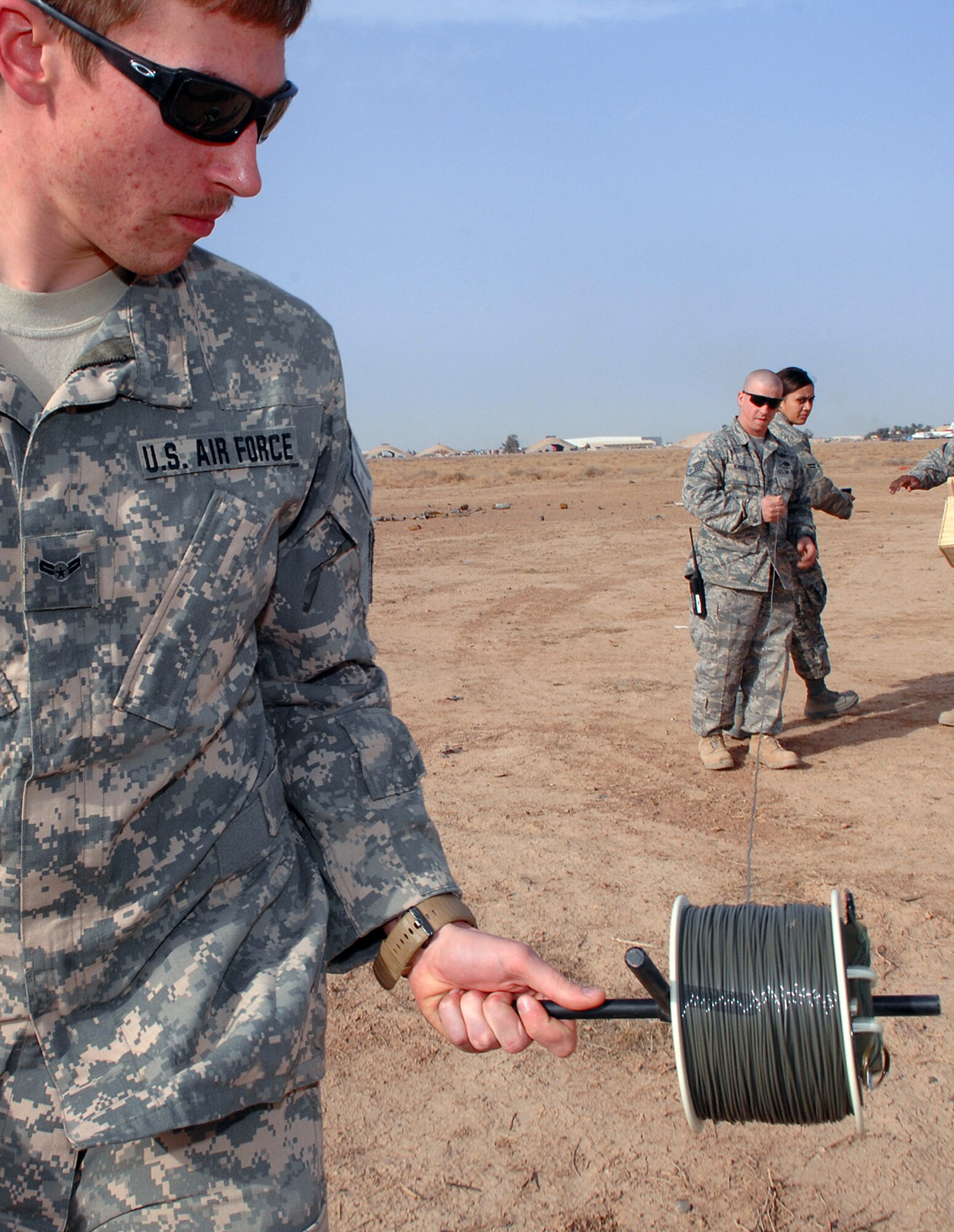 Airman 1st Class Brian Dunnagan rolls out shock tubing March 13 at Balad Air Base, Iraq. The tubing is connected to unexploded ordnances and used to initiate the blast from a safe distance. Airman Dunnagan is a 332nd Expeditionary Civil Engineer Squadron explosive ordnance disposal technician deployed from Hurlburt Field, Fla. (U.S. Air Force photo/Senior Airman Julianne Showalter) 