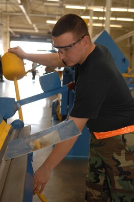 DYESS AIR FORCE BASE, Texas - Senior Airman Justin Shepard, bends a piece of sheet metal for a project March 10. The sheet metal shop work on many different parts of the B-1 and the C-130 such as, the wings, tails and the body. (U.S. Air Force photo by Airman 1st Class Jennifer Romig)