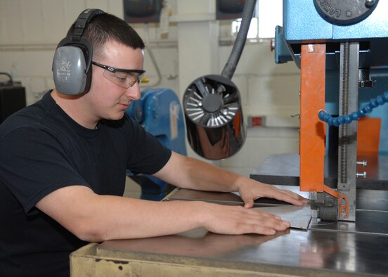 DYESS AIR FORCE BASE, Texas - Senior Airman  Justin Shepard, cuts through a piece of sheet metal March 10. The sheet metal shop is responsible for fixing big parts on the Dyess aircrafts such as wings, or a tail. They have base shop and a smaller team located on the flightline for quick fixes. (U.S. Air Force photo by Airman 1st Class Jennifer Romig)