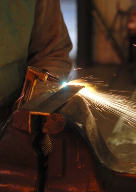 DYESS AIR FORCE BASE, Texas- Senior Airman Alan Fernandez cuts through a piece of metal March 10. The welding shop works mainly on C-130 and B-1 parts, but they can also weld any piece of metal machinery that needs to be fixed. (U.S. Air Force photo by Airman 1st Class Jennifer Romig)