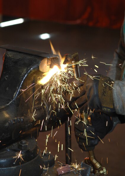 DYESS AIR FORCE BASE, Texas- Senior Airman Alan Fernandez cuts through a piece of metal March 10. The Aircraft Metal Technologists on base can work with anything made of metal. The shop can make its own aircraft brackets or simply weld to pieces of metal together. (U.S. Air Force photo by Airman 1st Class Jennifer Romig)