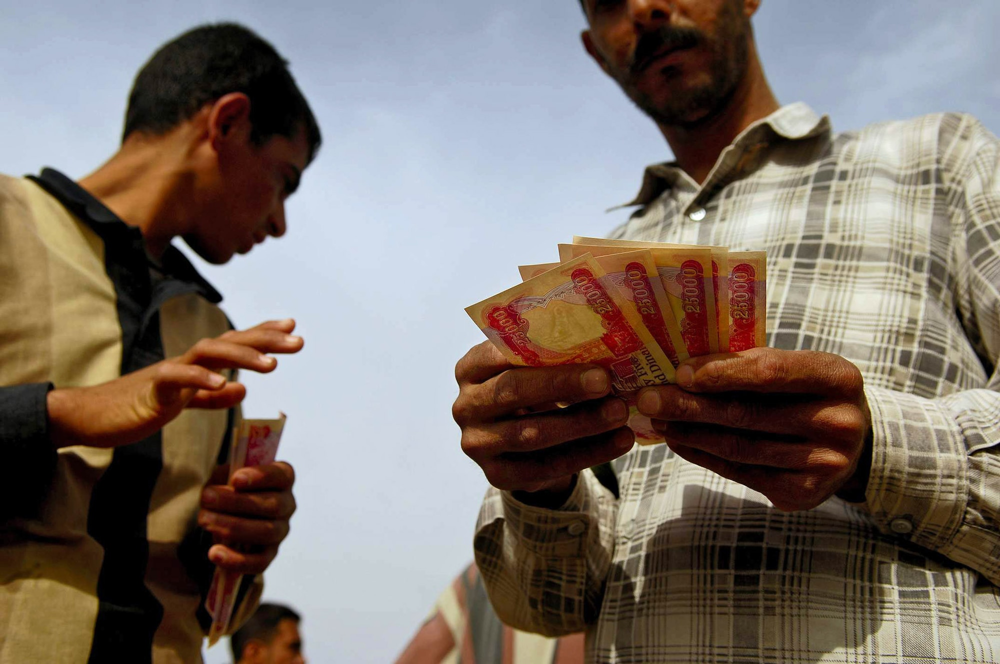 Iraqi students receive their first payday of 125,000 Iraqi Dinars, about $100, March 13 at the Red Horse Village of Hope school in Hawr Rajab, Iraq. Similar to a technical school, Iraqi students are taught rebuilding skills such as masonry, electrical and plumbing. Students a re paid $10 per school day they attend. (U.S. Air Force photo)
