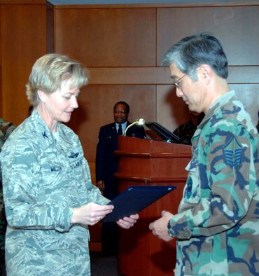 TRAVIS AIR FORCE BASE, Calif. -- You are appreciated:  Col. Maryanne Miller, 349th Air Mobility Wing commander hands a letter of appreciation to Master Sgt. Leslie Yu from the 349th Aircraft Maintenance Squadron. Sergeant Yu was one of the 17 volunteers from the 349th Air Mobility Wing who recently helped move the Yountville Veteran’s Home library from one building to another. (U.S. Air Force photo/Tech Sgt. Tony Castro)