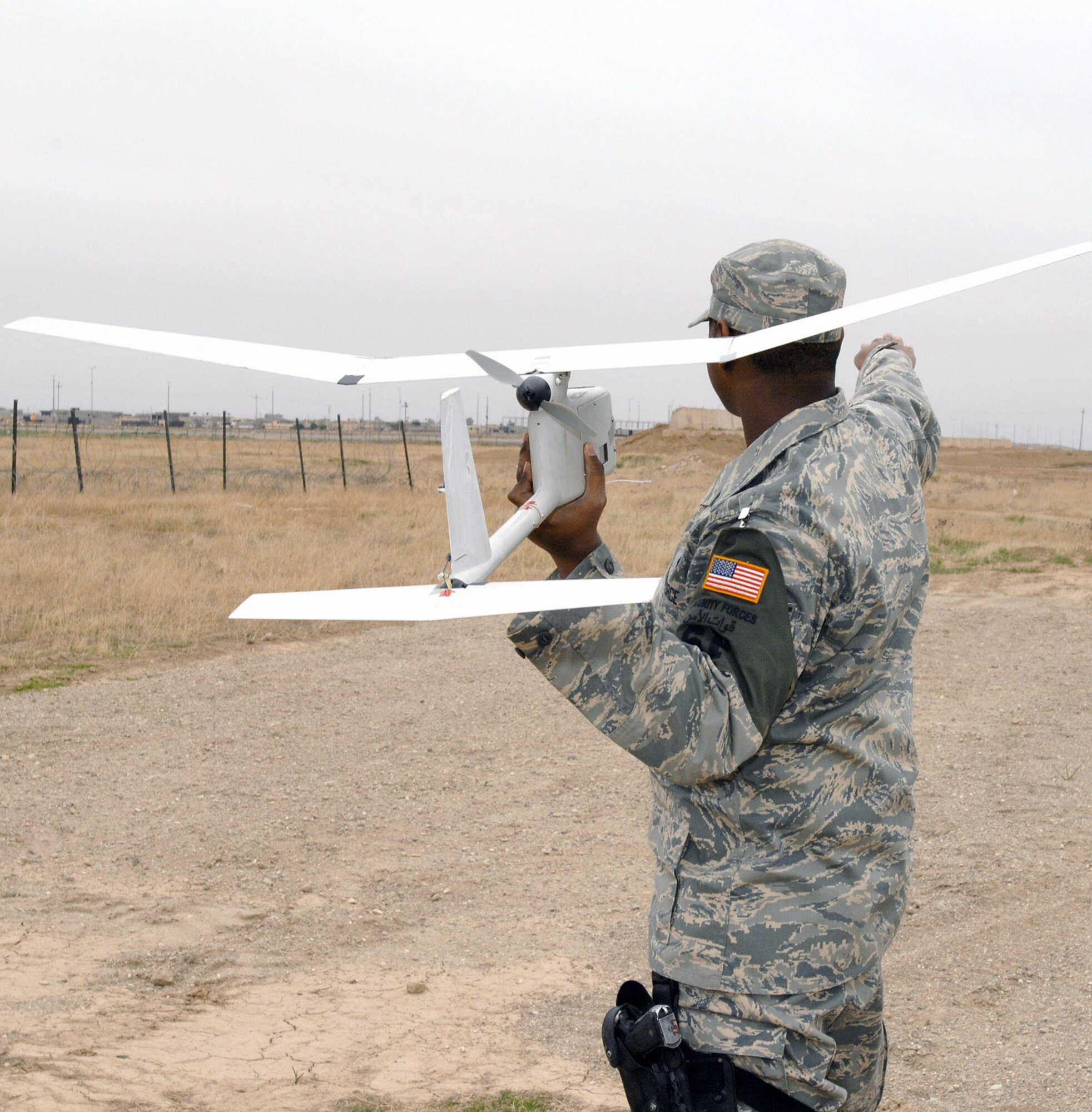 Senior Airman Glenn Gerald prepares to put an RQ-11 Raven in flight during a January mission at Kirkuk Air Base, Iraq. Despite weighing in at less than 5 pounds, these unmanned aerial vehicles play a vital role in securing the base and surrounding neighborhoods. Airman Gerald is a 506th Expeditionary Security Forces Squadron Raven operator. (U.S. Air Force photo/Senior Master Sgt. Don Senger) 
