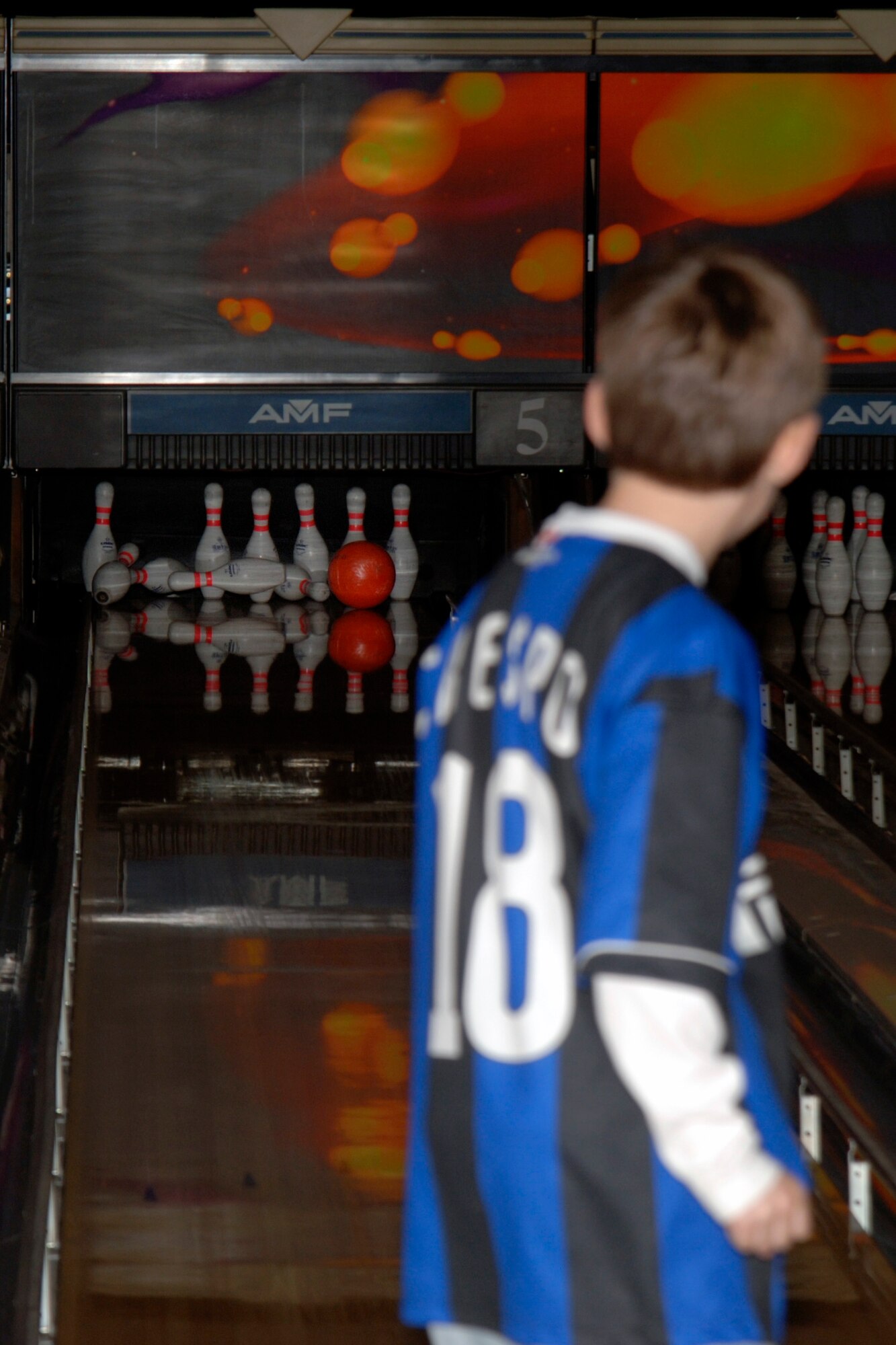Drew Hirselj, son of deployed Maj. Mark Hirselj, Air Mobility Command inspector general, watches as the pins fly during the Hearts Apart Bowling event inside the bowling alley on March 7.
(Photo by Senior Airman Kristin Capps)