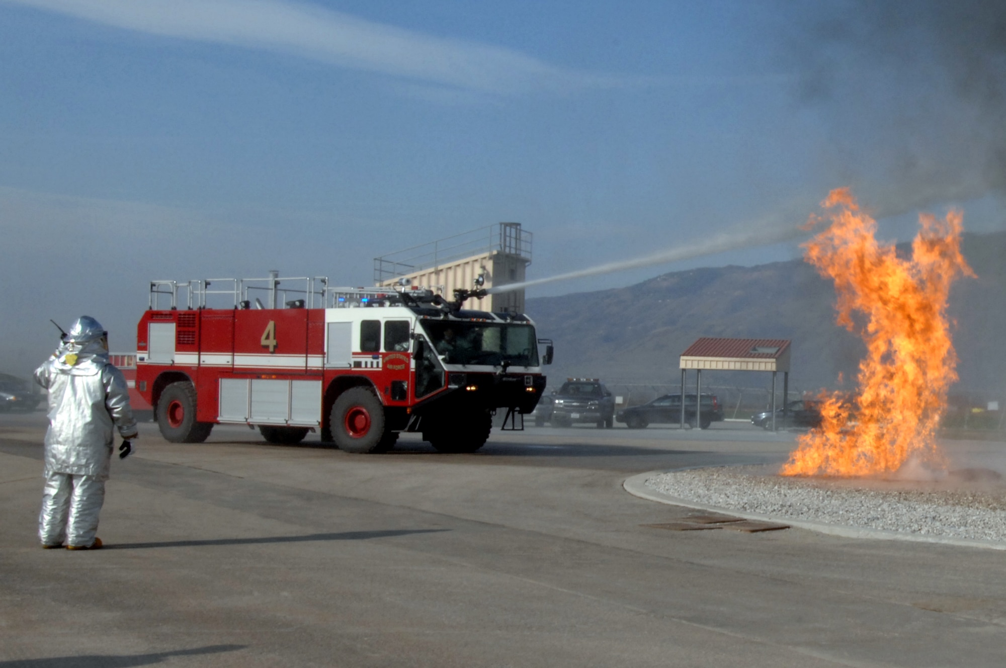 AVIANO AIR BASE, Italy--Aviano firefighters use a fire truck to help extinguish a simulated aircraft fire at the new firefighting training facility on base March 14, 2008.  The new live fire training facility will allow Aviano firefighters to continuously train throughout the year.  (U.S. Air Force photo/Airman 1st Class Tabitha M. Mans)
