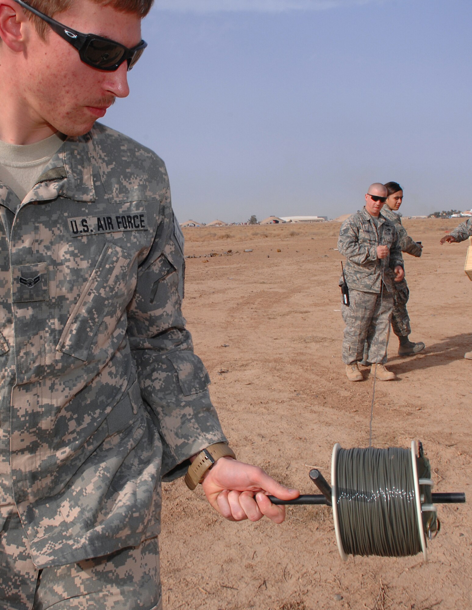 BALAD AIR BASE, Iraq -- Airman 1st Class Brian Dunnagan, 332nd Expeditionary Civil Engineer Squadron explosive ordnance disposal technician, rolls out shock tubing here, March 13. The tubing is connected to unexploded ordnances and used to initiate the blast from a safe distance. Airman Dunnagan is deployed from Hurlburt Field, Fla. (U.S. Air Force photo/ Senior Airman Julianne Showalter)