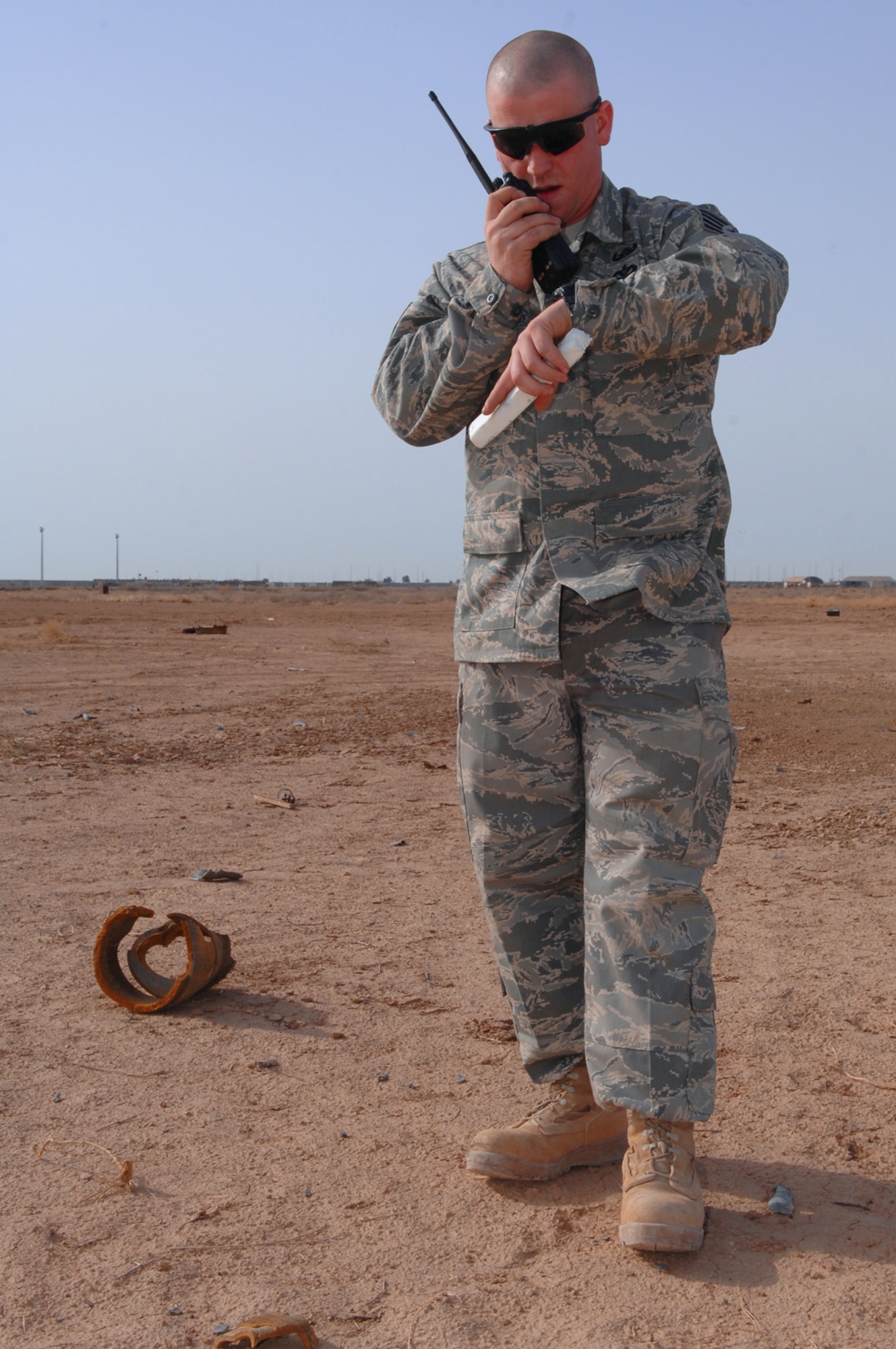 BALAD AIR BASE, Iraq -- Staff Sgt. Jason Kreider, 332nd Expeditionary Civil Engineer Squadron explosive ordnance disposal technician, calls into the command post to report a controlled detonation here, March 13. Unexploded ordnances that have been collected from indirect fire attacks must be blown up to prevent them from reentering opposing forces' hands. Sergeant Kreider is deployed from Fort Dix, N.J. (U.S. Air Force photo/ Senior Airman Julianne Showalter)