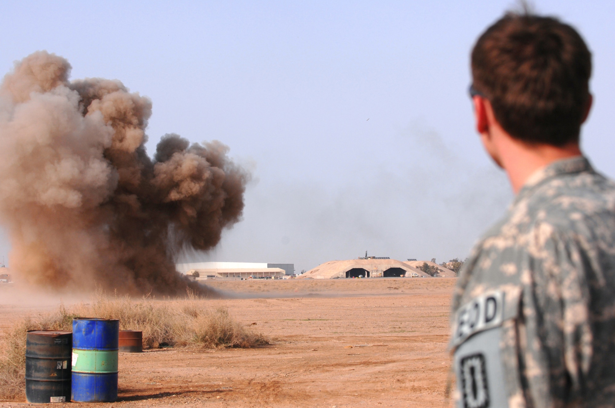 BALAD AIR BASE, Iraq -- Airman 1st Class Brian Dunnagan, 332nd Expeditionary Civil Engineer Squadron explosive ordnance disposal technician, stands by as a controlled detonation is successfully completed here, March 13. Unexploded ordnances are collected and destroyed during controlled detonations to prevent them from reentering opposing forces' hands. Airman Dunnagan is deployed from Hurlburt Field, Fla. (U.S. Air Force photo/ Senior Airman Julianne Showalter)