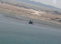 KUNSAN AIR BASE, Republic of Korea -- An Apache AH-64 returns to base after engaging its AGM-114 Hellfire missiles at a target site here March 14.  Fifteen Apaches from the Army's 2nd Combat Aviation Brigade trained with live fire over Chikdo Range, an island in the West Sea, during a joint "buddy laze" training with Kunsan F-16 pilots.  (U.S. Air Force photo/Senior Airman Steven R. Doty)