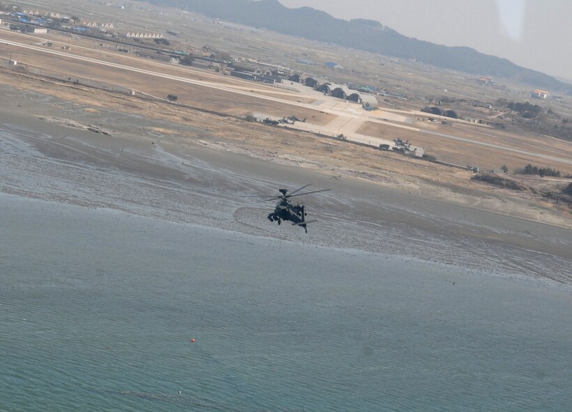 KUNSAN AIR BASE, Republic of Korea -- An Apache AH-64 returns to base after engaging its AGM-114 Hellfire missiles at a target site here March 14.  Fifteen Apaches from the Army's 2nd Combat Aviation Brigade trained with live fire over Chikdo Range, an island in the West Sea, during a joint "buddy laze" training with Kunsan F-16 pilots.  (U.S. Air Force photo/Senior Airman Steven R. Doty)