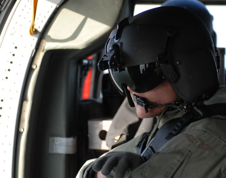 KUNSAN AIR BASE, Republic of Korea -- Private First Class Caleb Caulder, AH-64 Crew Chief, ensures clearance on his side of the Apache during flight here March 14.  Fifteen Apaches from the Army's 2nd Combat Aviation Brigade trained with live fire over Chikdo Range, an island in the West Sea, during a joint "buddy laze" training with Kunsan F-16 pilots.  (U.S. Air Force photo/Senior Airman Steven R. Doty)