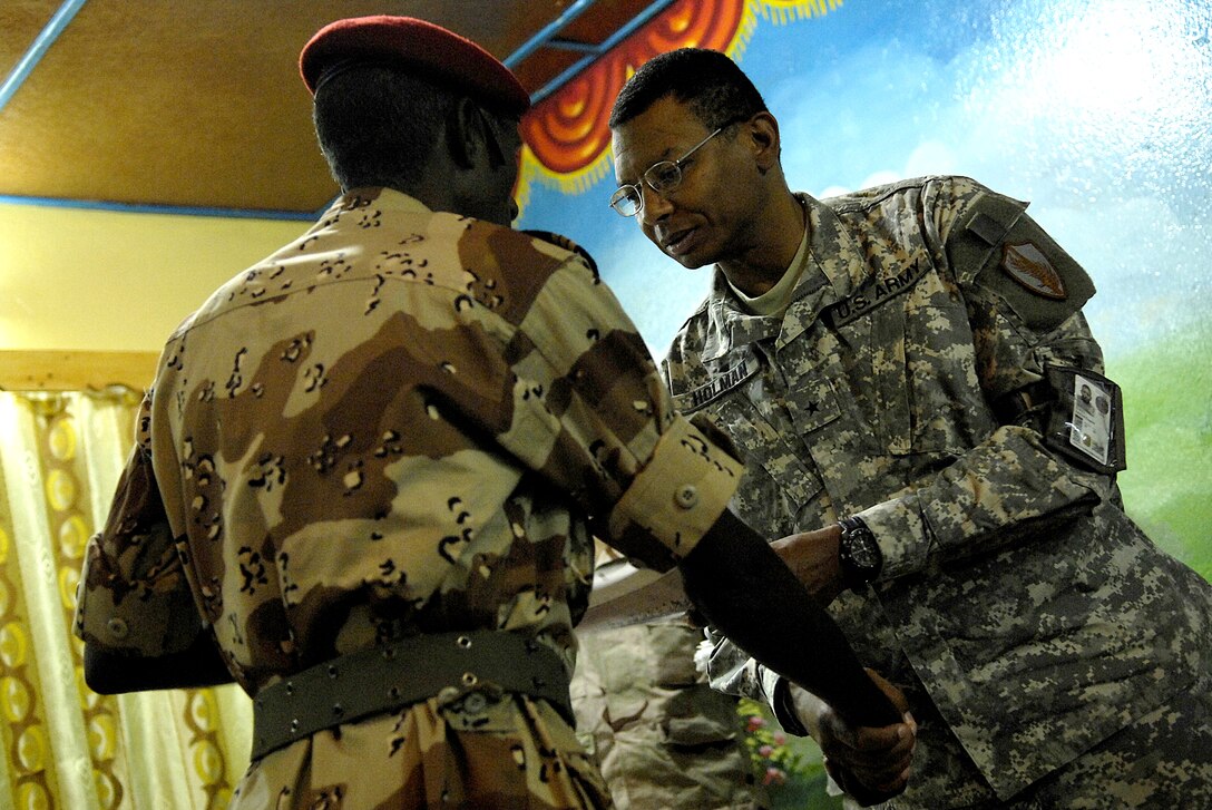 U.S. Army Brig. Gen. Sanford Holman, commander, Combined Joint Task Force-Horn of Africa, presents a certificate and congratulates a Djiboutian army soldier during a graduation ceremony at Forward Operating Location Ali Sabieh, Djibouti, March 11, 2008.