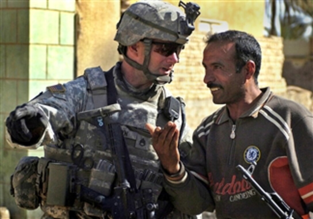 U.S. Army Staff Sgt. Jeremy Brown, left, talks with a local Son of Iraq in Himbus, Iraq, March 8, 2008. Brown is a platoon sergeant assigned to the 1st Armored Division's Company I, 3rd Squadron, 2nd Stryker Cavalry Regiment.