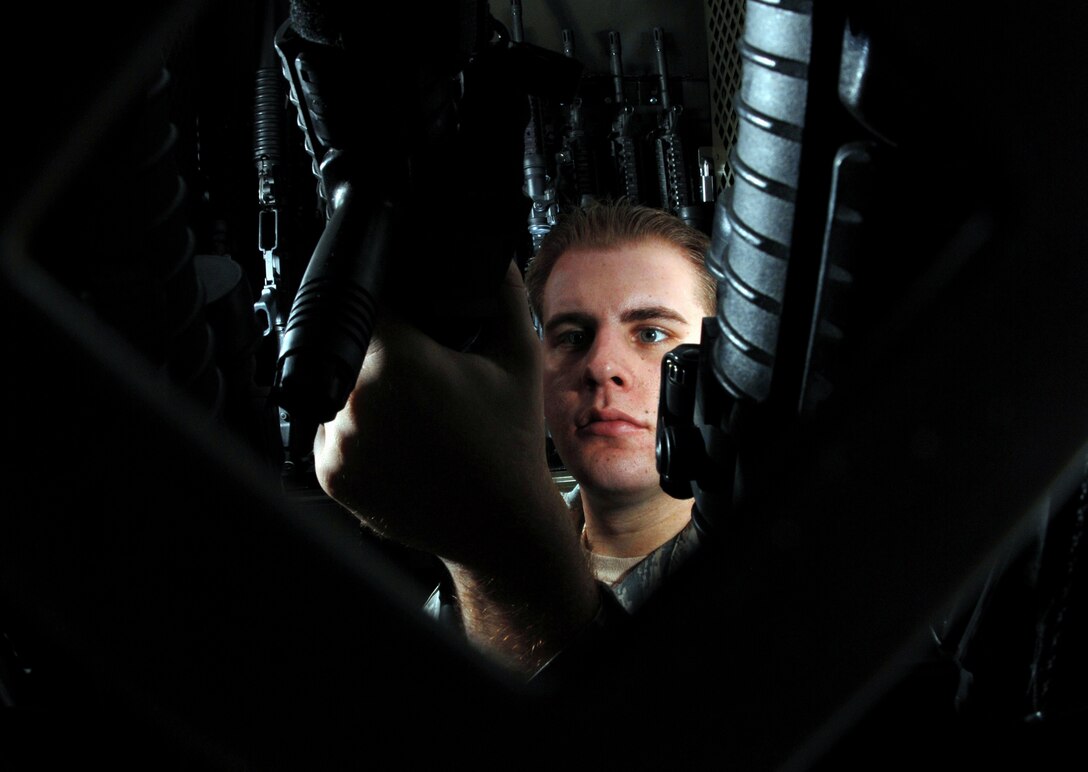 Staff Sgt. Andrew Fennell, an armorer from the 452nd Security Forces Squadron, March Air Reserve Base, Calif., visually inspects the M-68 scope on an 5.56 mm M4 carbine rifle at the armory. (U.S. Air Force photo by Val Gempis)