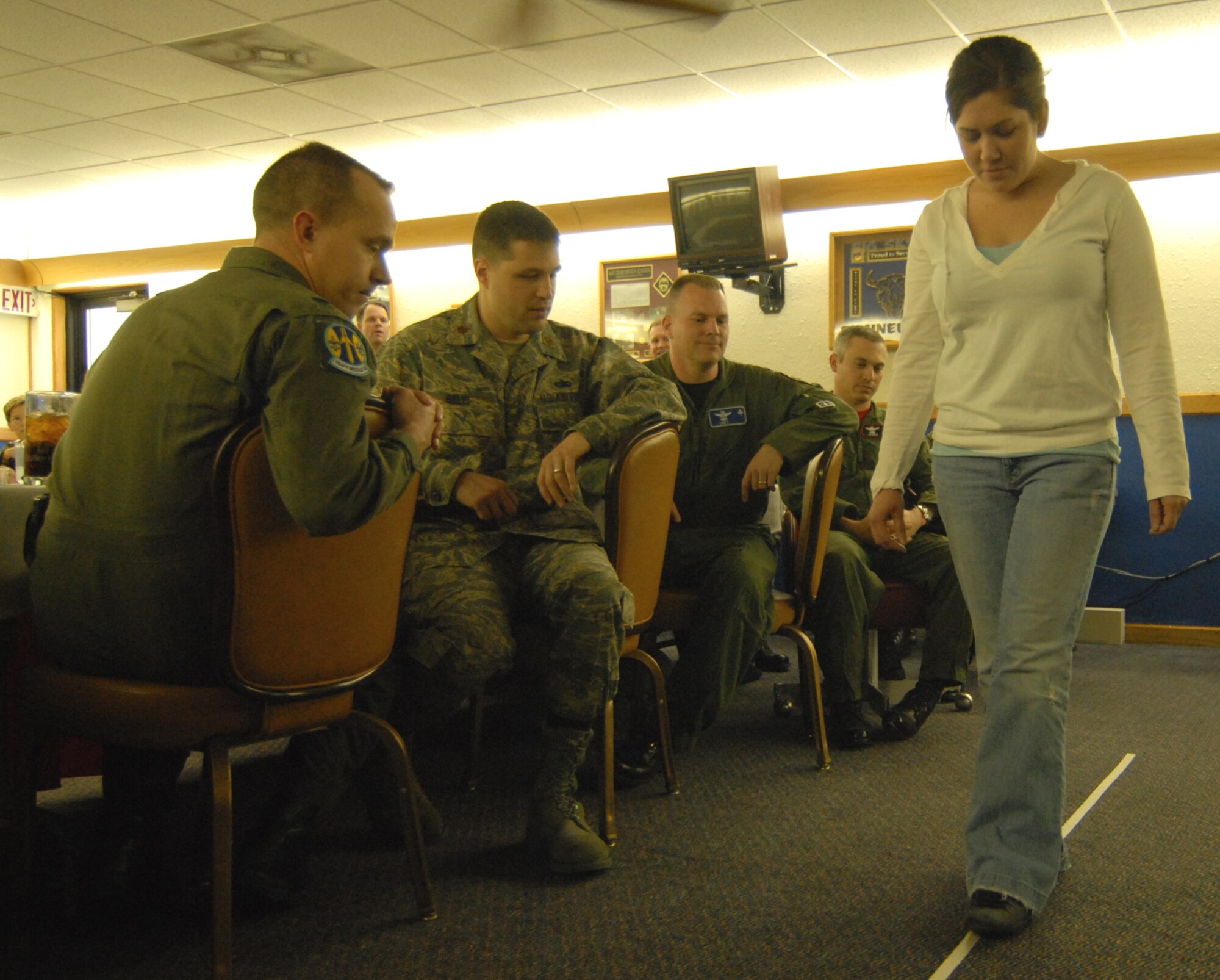 Staff Sgt. Winda Sidor, 341st Space Wing legal office, takes part in a field sobriety test as base commanders observe a dangerous driver awareness and DUI demonstration at Malmstrom’s Grizzly Bend Club March 14. The demonstration focused on the varying levels of intoxication and educated base commanders on the procedures security forces use to identify dangerous drivers and process them if determined to be impaired. This test helps determine a driver’s sense of balance. (U.S. Air Force photo/John Turner)