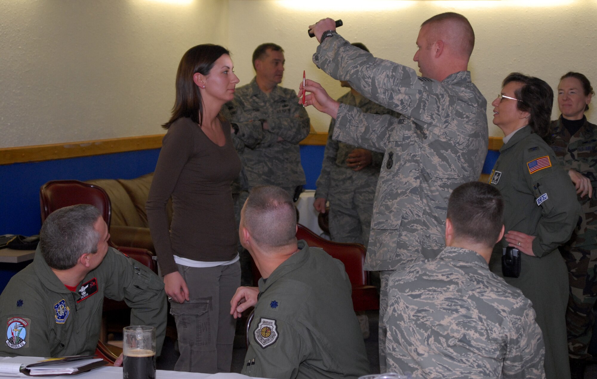 Staff Sgt. Joseph Knowles, 341st Security Forces Squadron, conducts a Horizontal Gaze Nystagmus Test on 1st Lt. Alisha Mason, 341st SFS, while Col. Sandra Finan, 341st Space Wing commander, right, and other base commanders observe a dangerous driver awareness and DUI demonstration at the Malmstrom’s Grizzly Bend Club March 14. The demonstration focused on the varying levels of intoxication and educated base commanders on the procedures security forces use to identify dangerous drivers and process them if determined to be impaired. The Horizontal Gaze Nystagmus Test is designed to look for involuntary eye movement when the eye is at extreme angles. If the eye is determined to have the involuntary movement, the driver is determined to be impaired. (U.S. Air Force photo/John Turner)