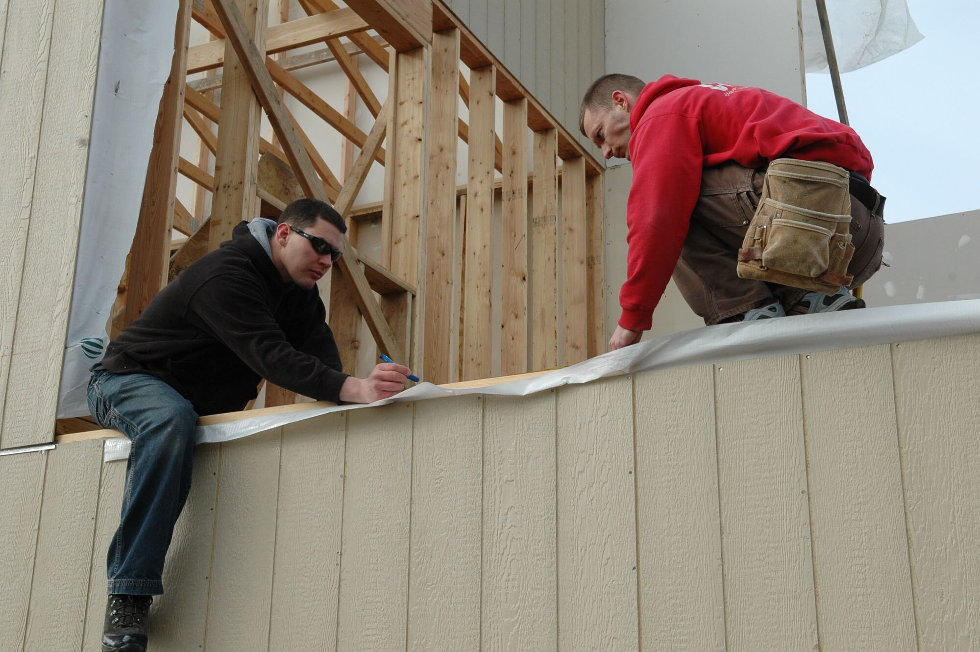 SPOKANE, Wash. – From left, Staff Sgt. Paul Maples and Senior Airman Michael Gerry of the 66th Training Squadron at Fairchild Air Force Base, Wash., lay out a window frame on a Habitat for Humanity home March 13. About 15 Airmen from the 66th TRS volunteered their off day to work on the home, which is part of a Habitat-Spokane project of 31 Union Street homes started in 1999. Habitat sells the constructed homes to low-income families at cost with a zero-percent interest rate, made possible mainly because of the volunteer labor. (U.S. Air Force photo / Tech. Sgt. Larry W. Carpenter Jr.)