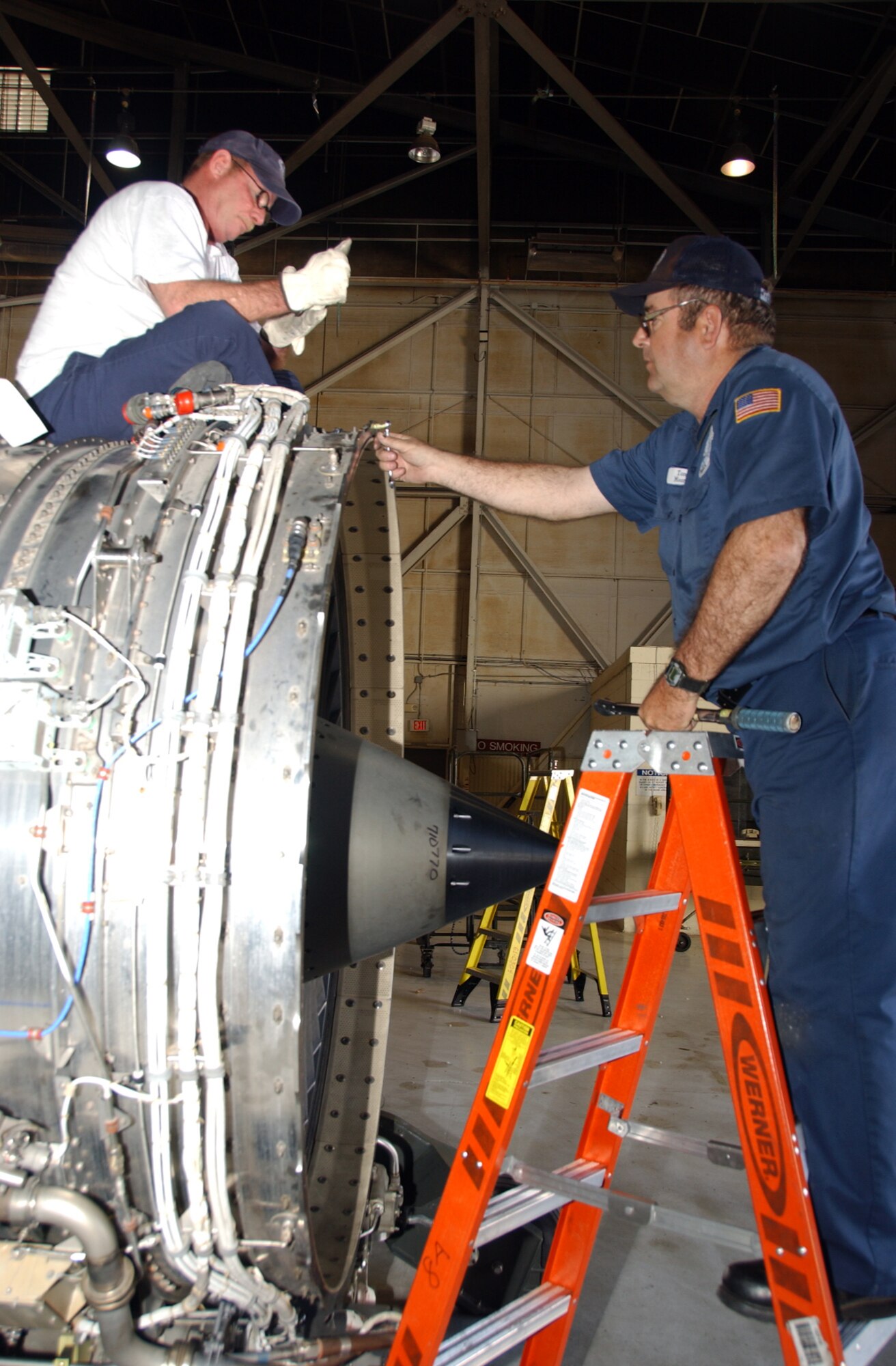 ALTUS AIR FORCE BASE, Okla. -- From left, 97th Tanker Sortie Generation Engine Mechanics Kim Cather and Tom Moore work together to install a engine ring cowl during an engine swap of a General Electric F-108 engine, which was overhauled by Tinker Air Force Base, Okla., for a KC-135R Stratotanker in Hangar 523 March 14. The KC-135Rs have been in service for almost 50 years and requires routine maintenance in order to remain operational. (Photo by Senior Airman Clinton Atkins)